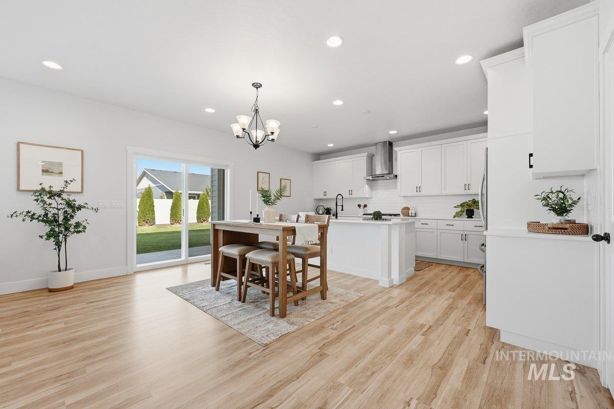 Dining room featuring recessed lighting, light wood-style flooring, and a chandelier