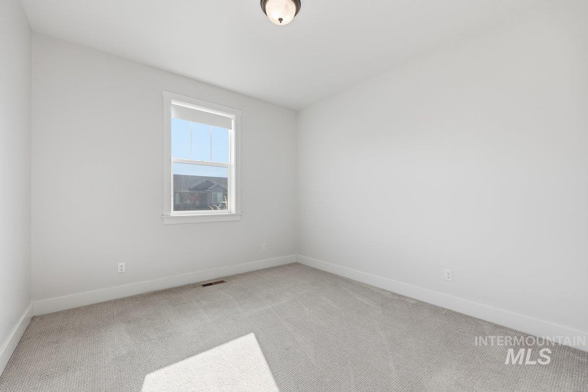 Carpeted spare room with baseboards