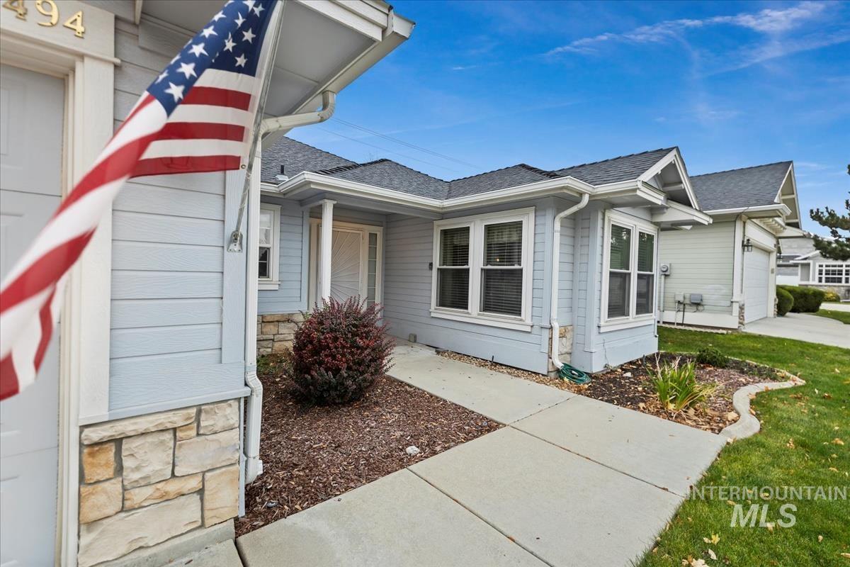 View of home's exterior featuring roof with shingles, a garage, and stone siding