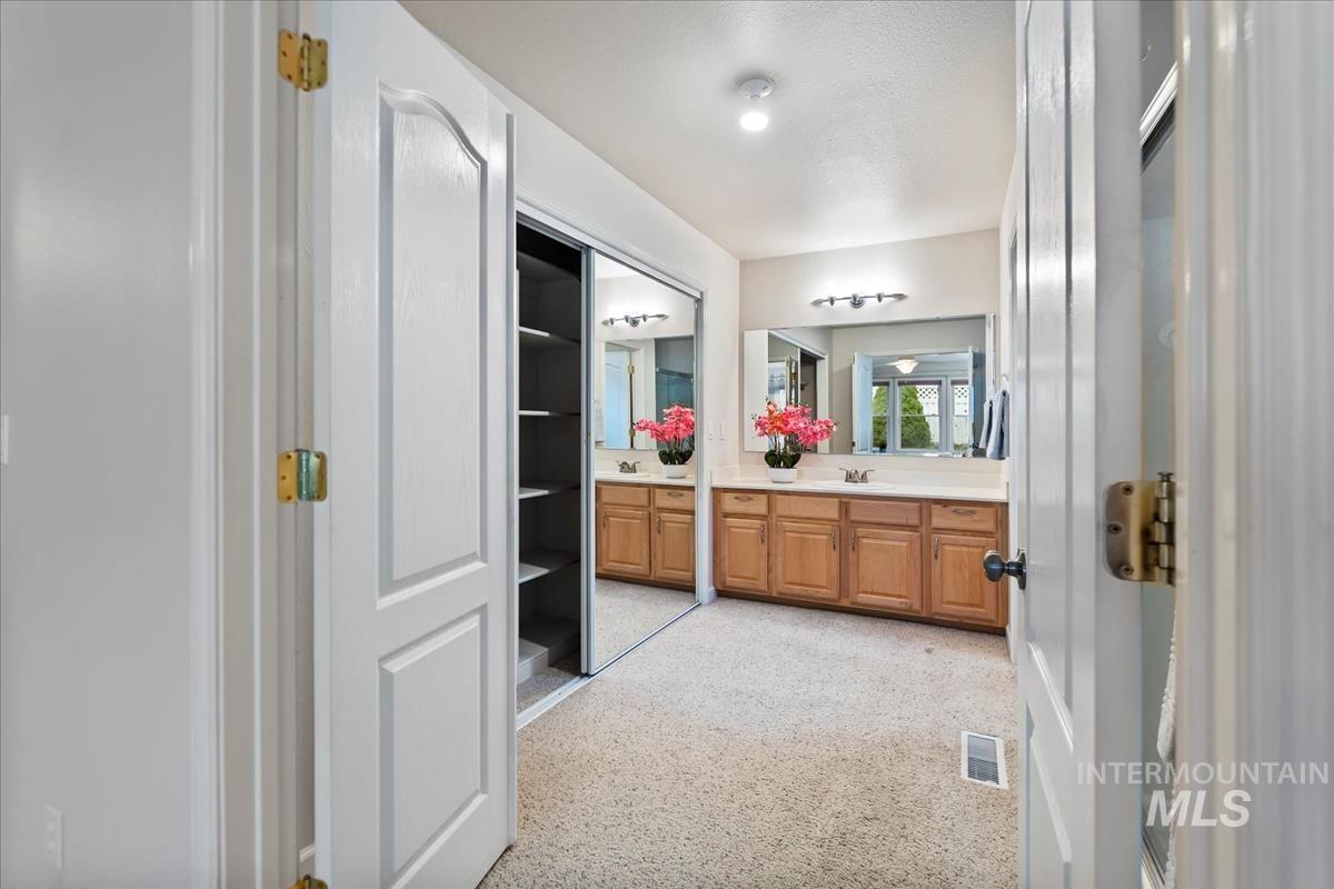 Bathroom with vanity, dark speckled floor, and a closet