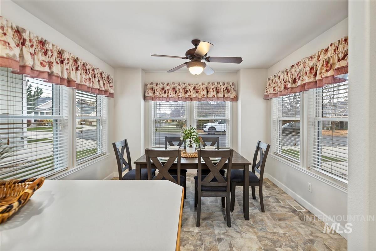 Dining area with stone finish floors and ceiling fan