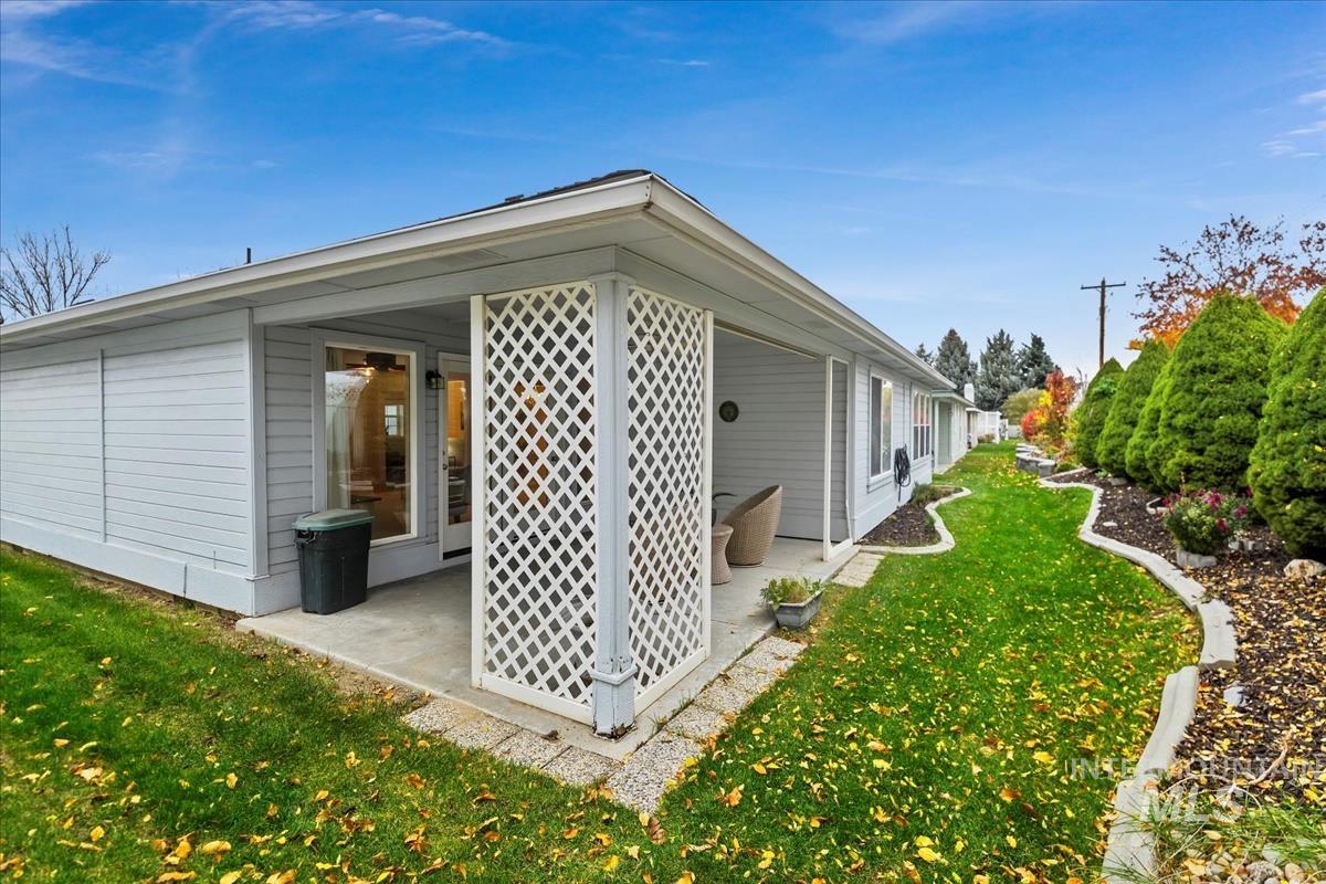 View of side of home with a yard and a patio
