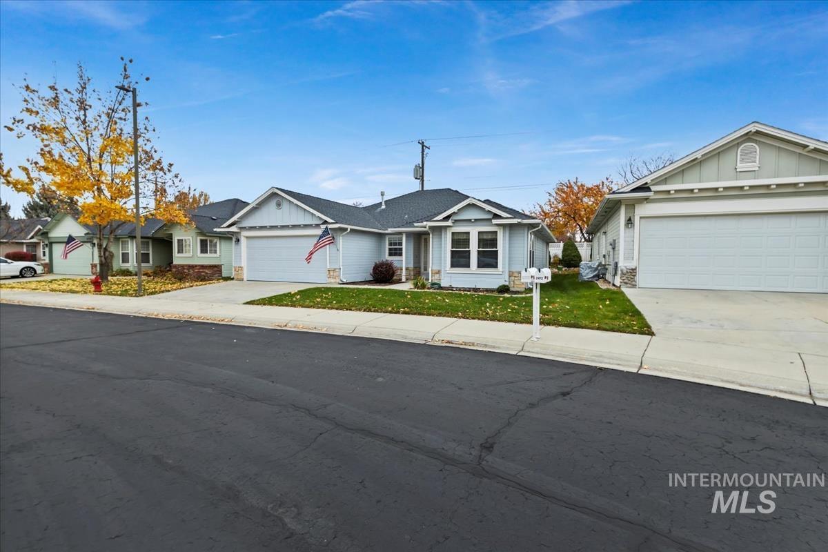 Ranch-style home with board and batten siding, driveway, a garage, and a front yard