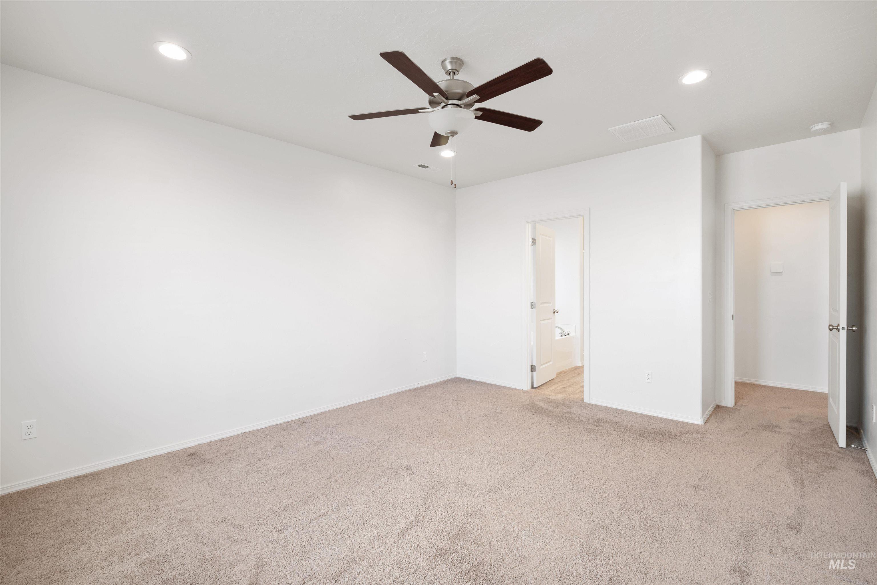 Unfurnished bedroom featuring recessed lighting, light colored carpet, ceiling fan, and connected bathroom