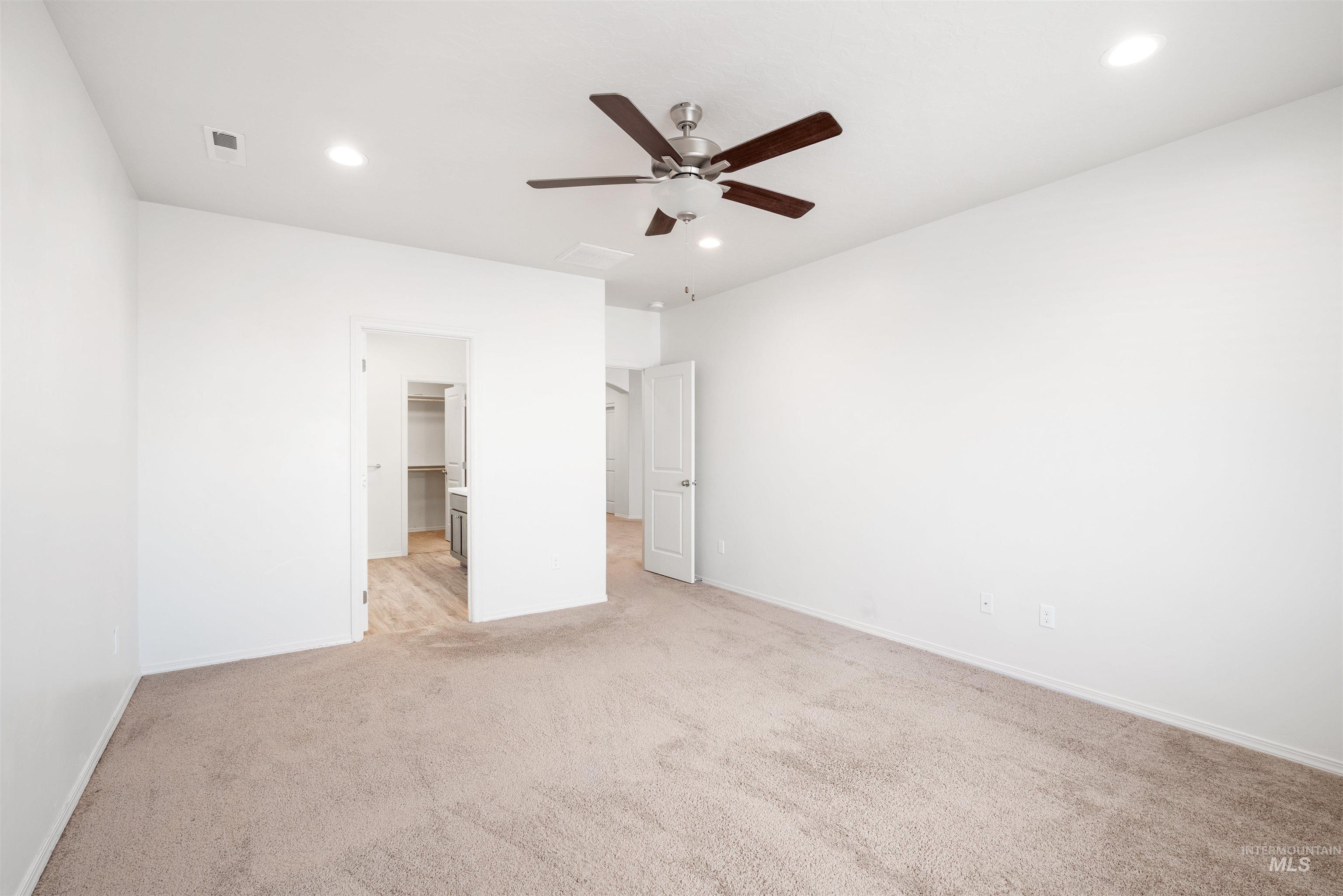 Unfurnished bedroom with a spacious closet, carpet flooring, a ceiling fan, and recessed lighting