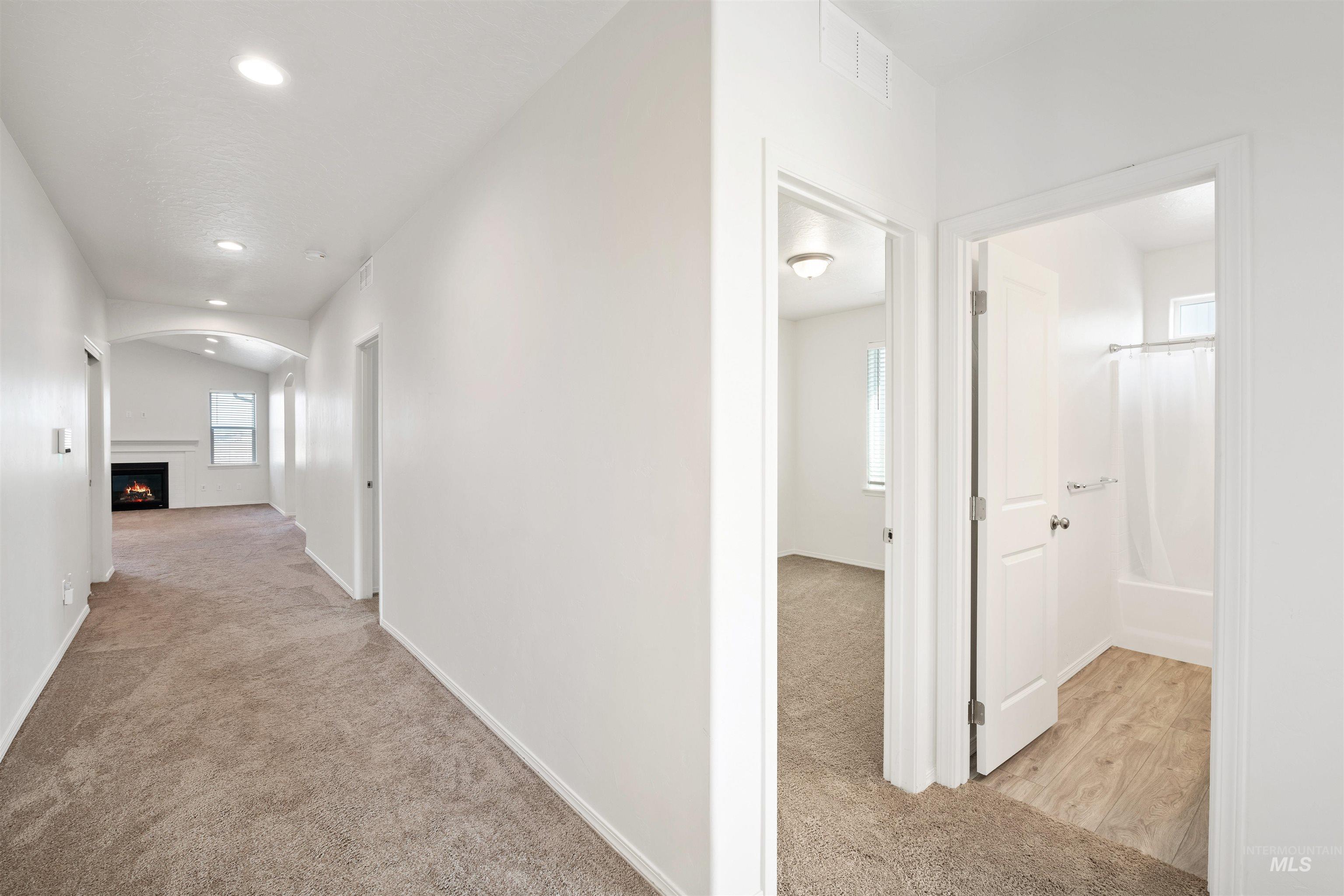 Hall with light carpet and recessed lighting