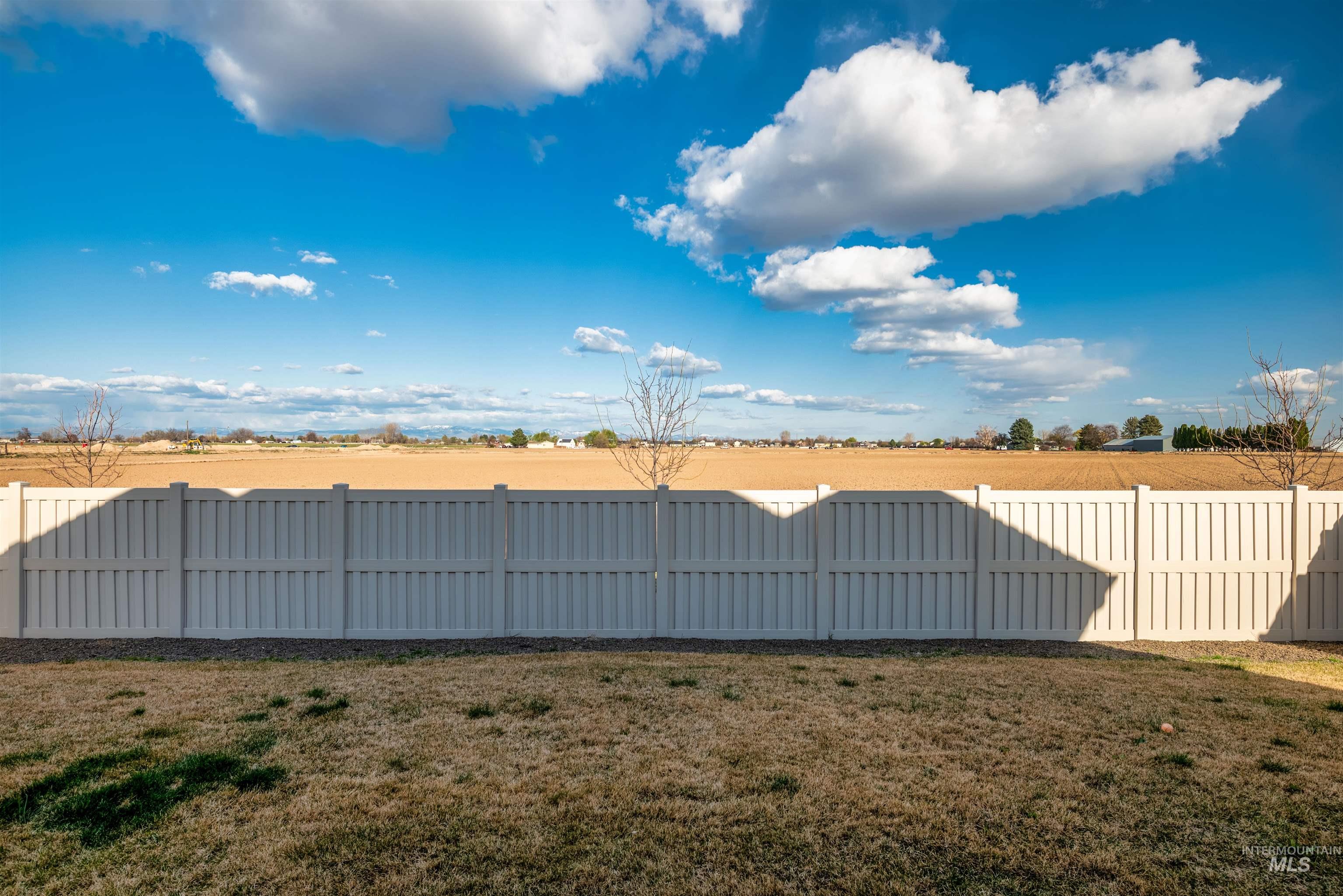 Fenced backyard with a view of rural / pastoral area