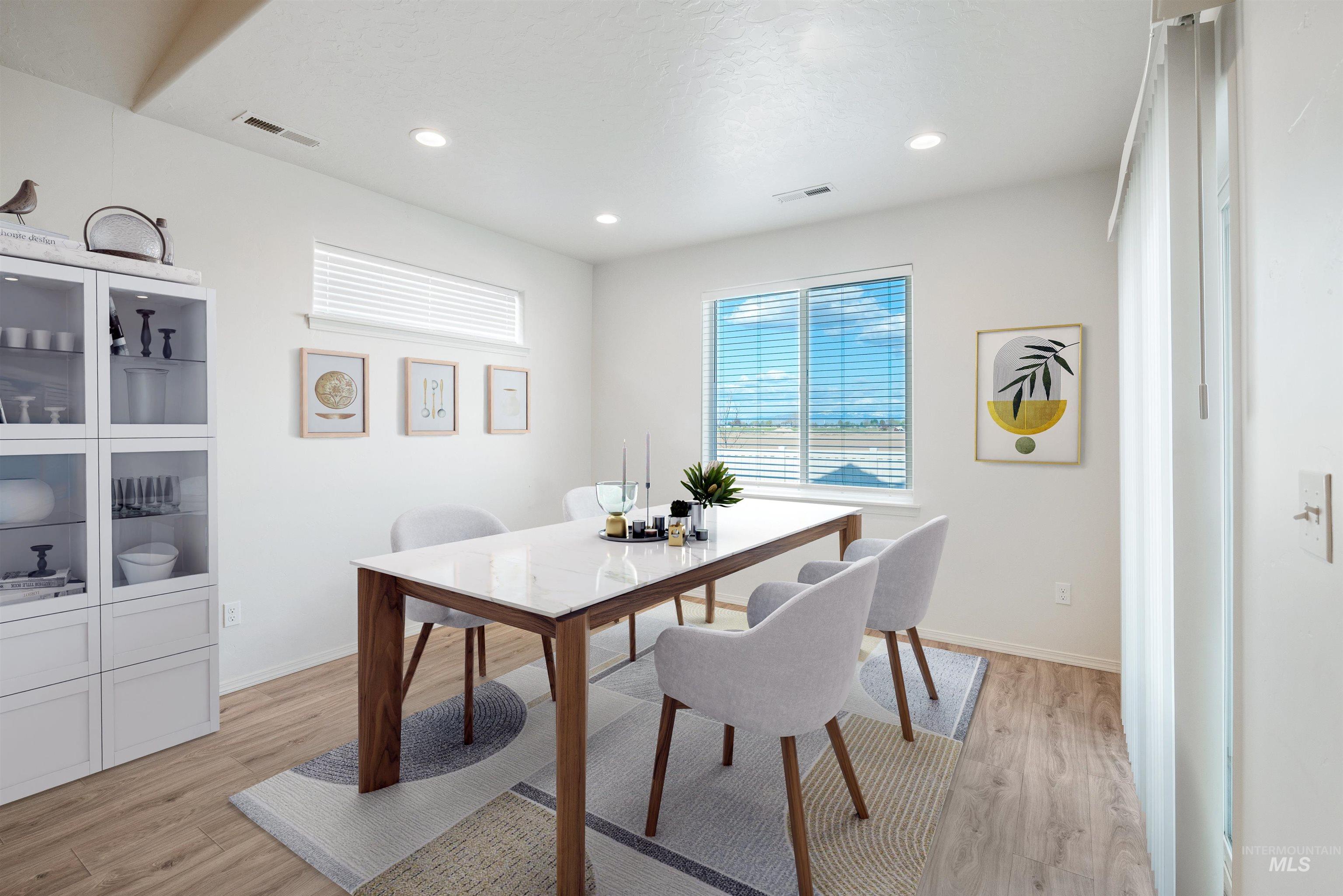 Dining area with light wood-style floors and recessed lighting