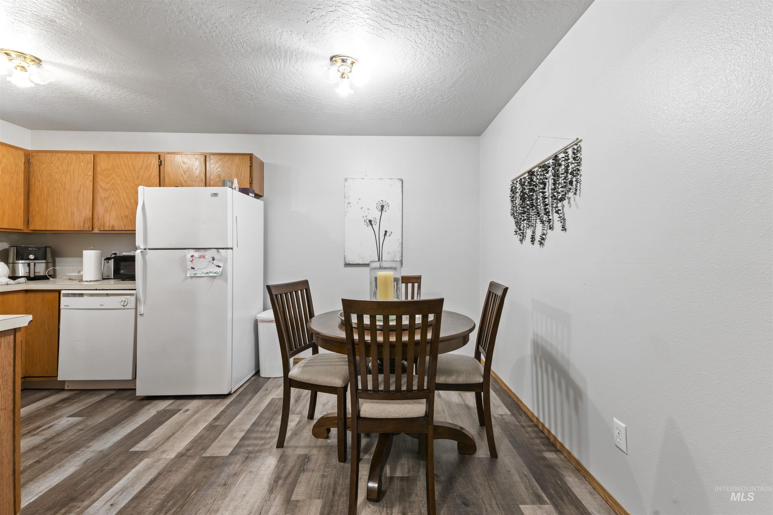 Dining room featuring light wood-style flooring and a textured ceiling