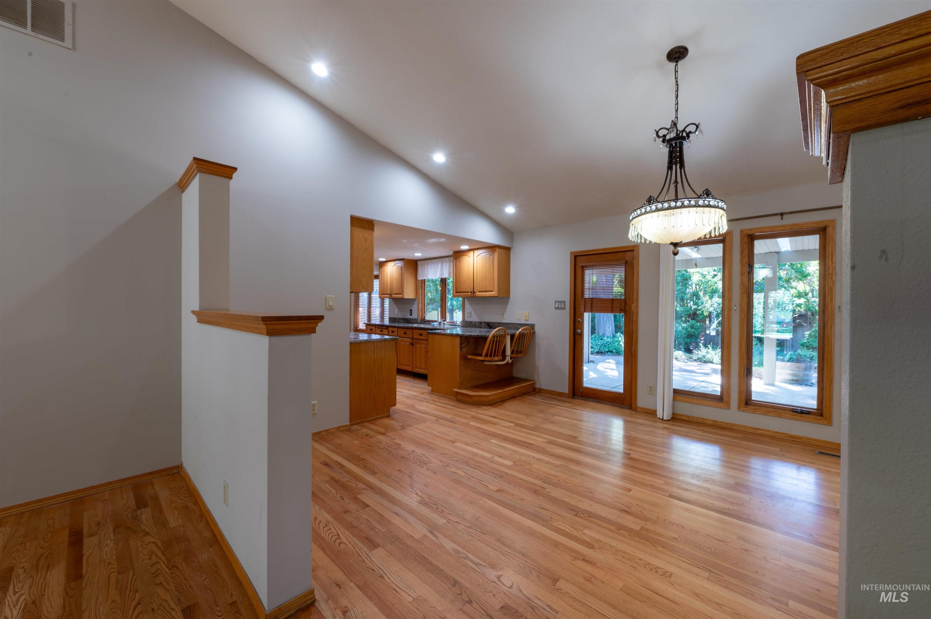 Kitchen featuring dark countertops, recessed lighting, light wood-type flooring, pendant lighting, and a peninsula