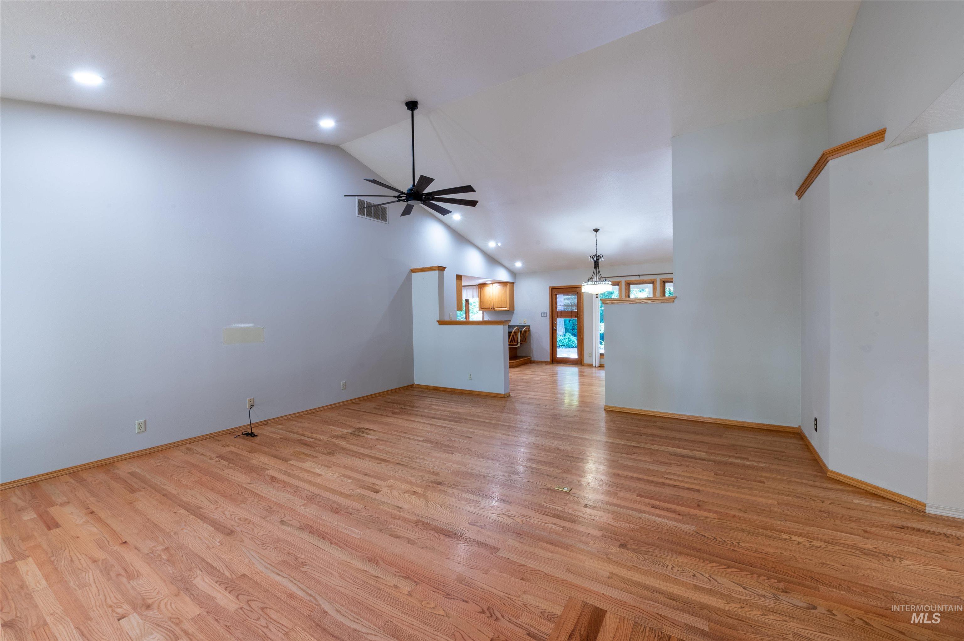 Unfurnished living room featuring light wood-style floors, ceiling fan, recessed lighting, and high vaulted ceiling