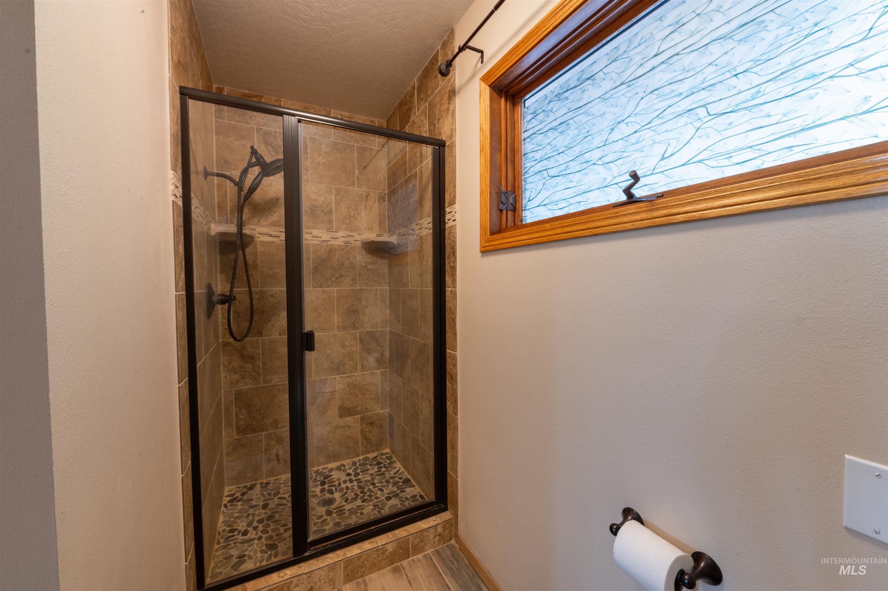 Full bathroom featuring a stall shower and a textured ceiling