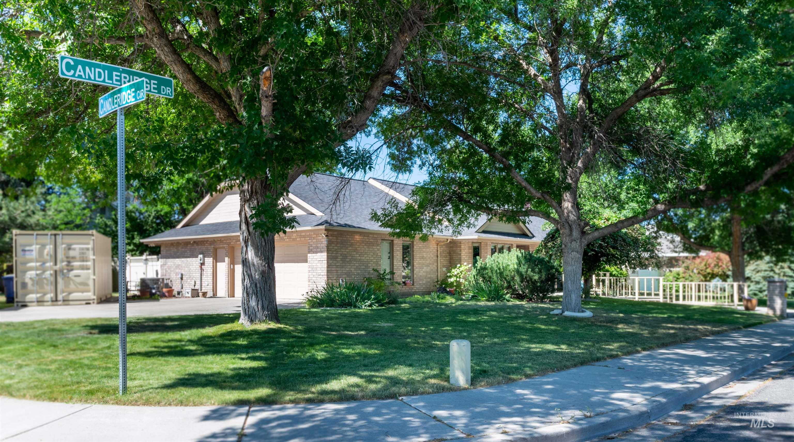 View of front facade with a garage, brick siding, and driveway