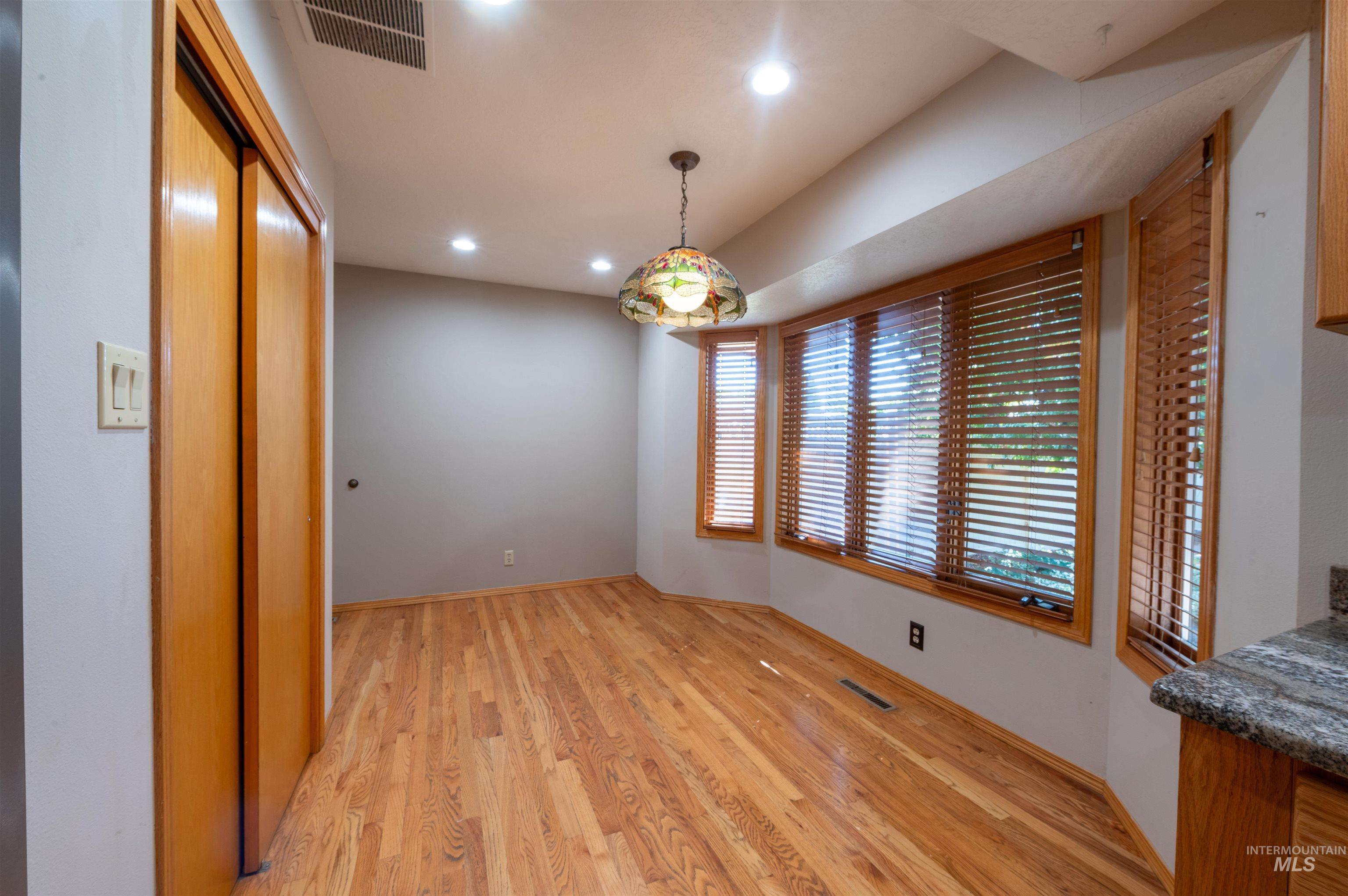 Unfurnished dining area with light wood-style flooring and recessed lighting