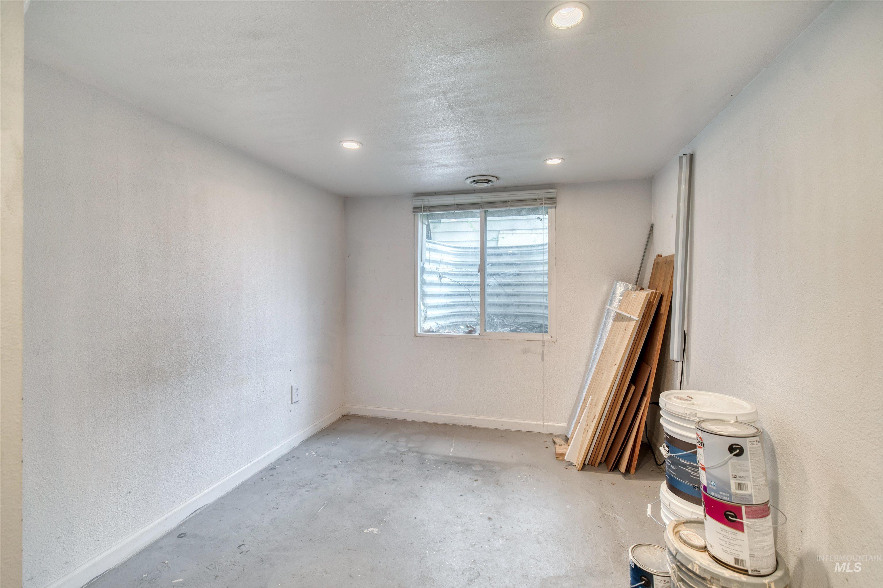 Spare room with concrete flooring, recessed lighting, and a textured wall