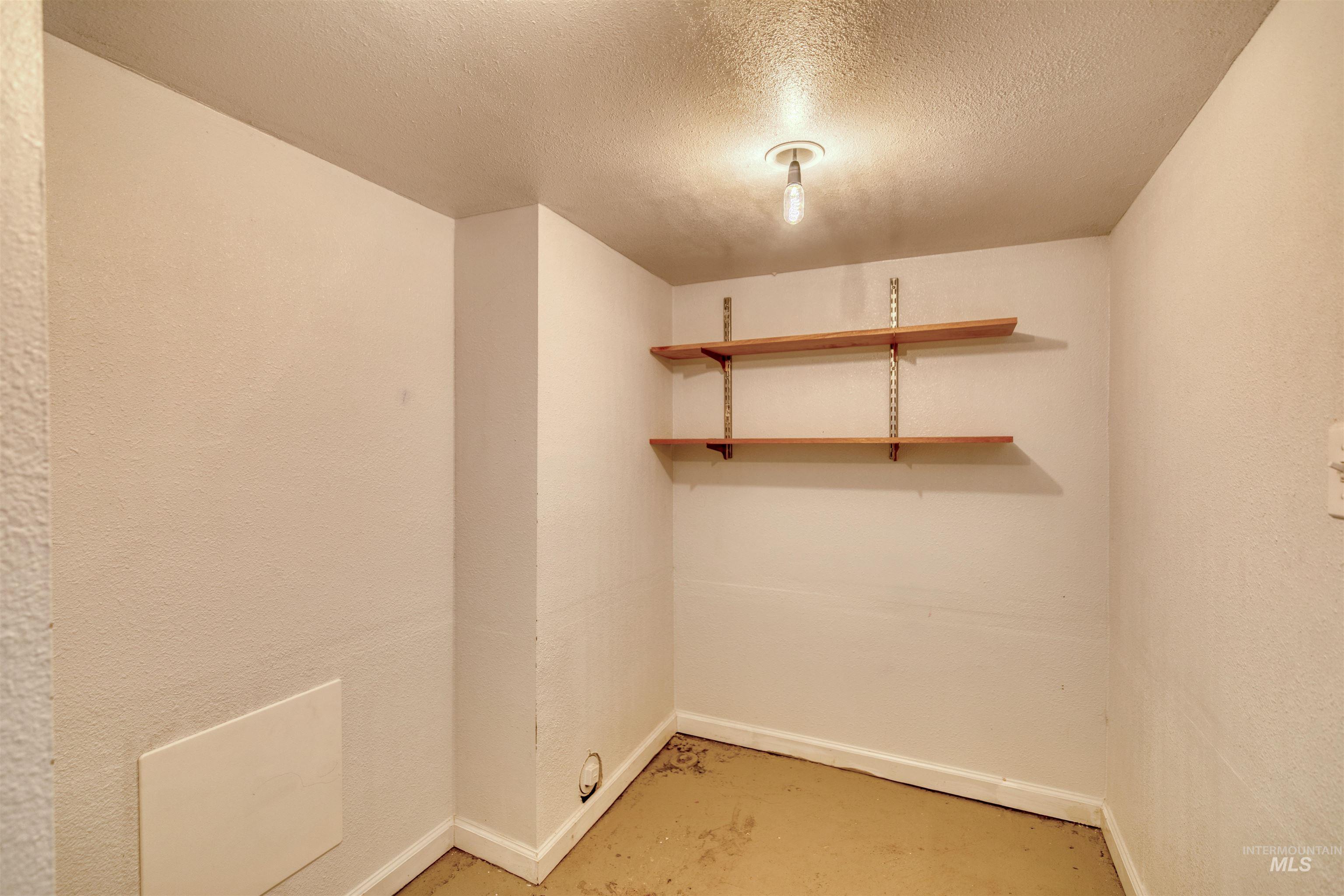 Washroom with baseboards and a textured ceiling