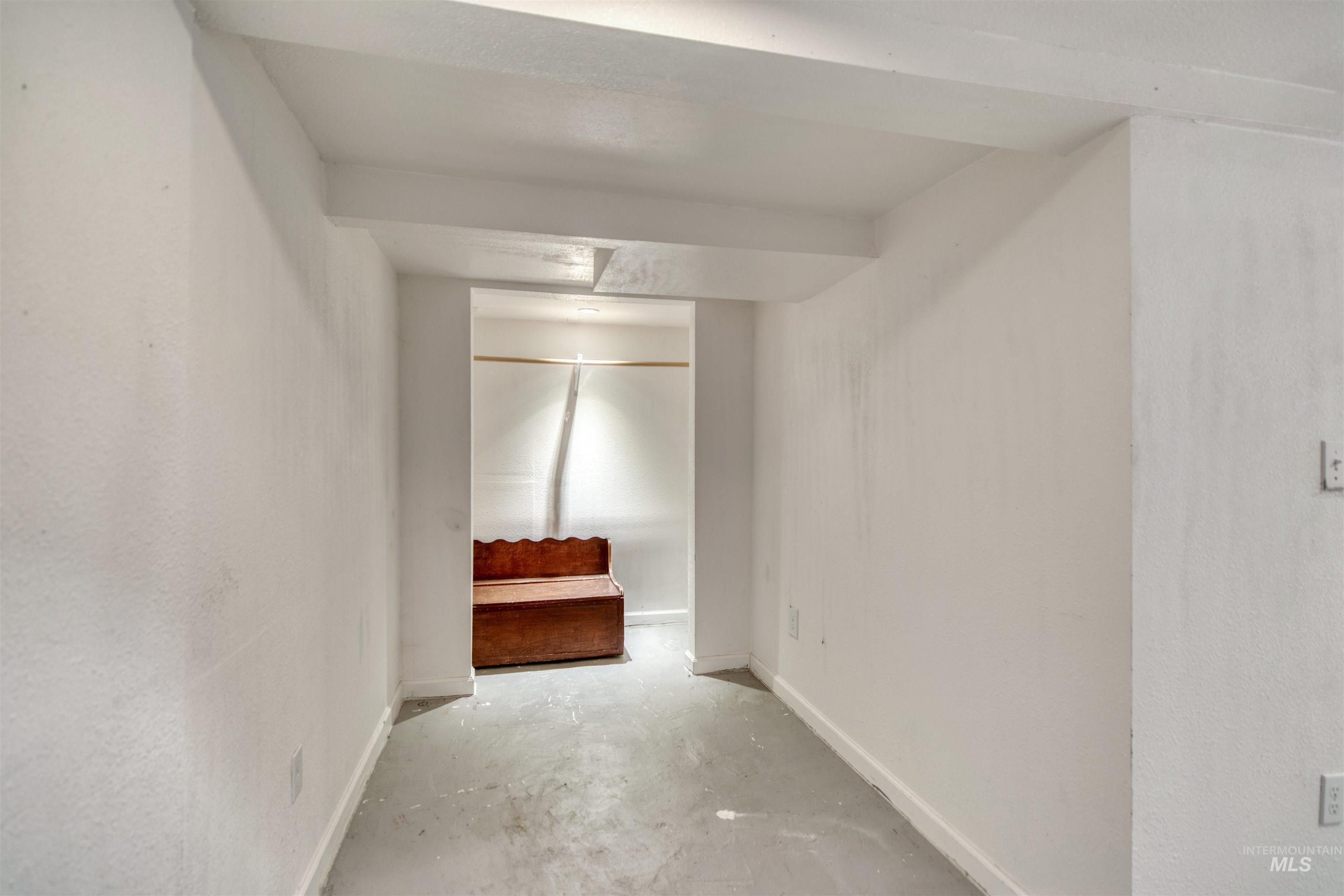 Unfurnished bedroom featuring baseboards and concrete flooring