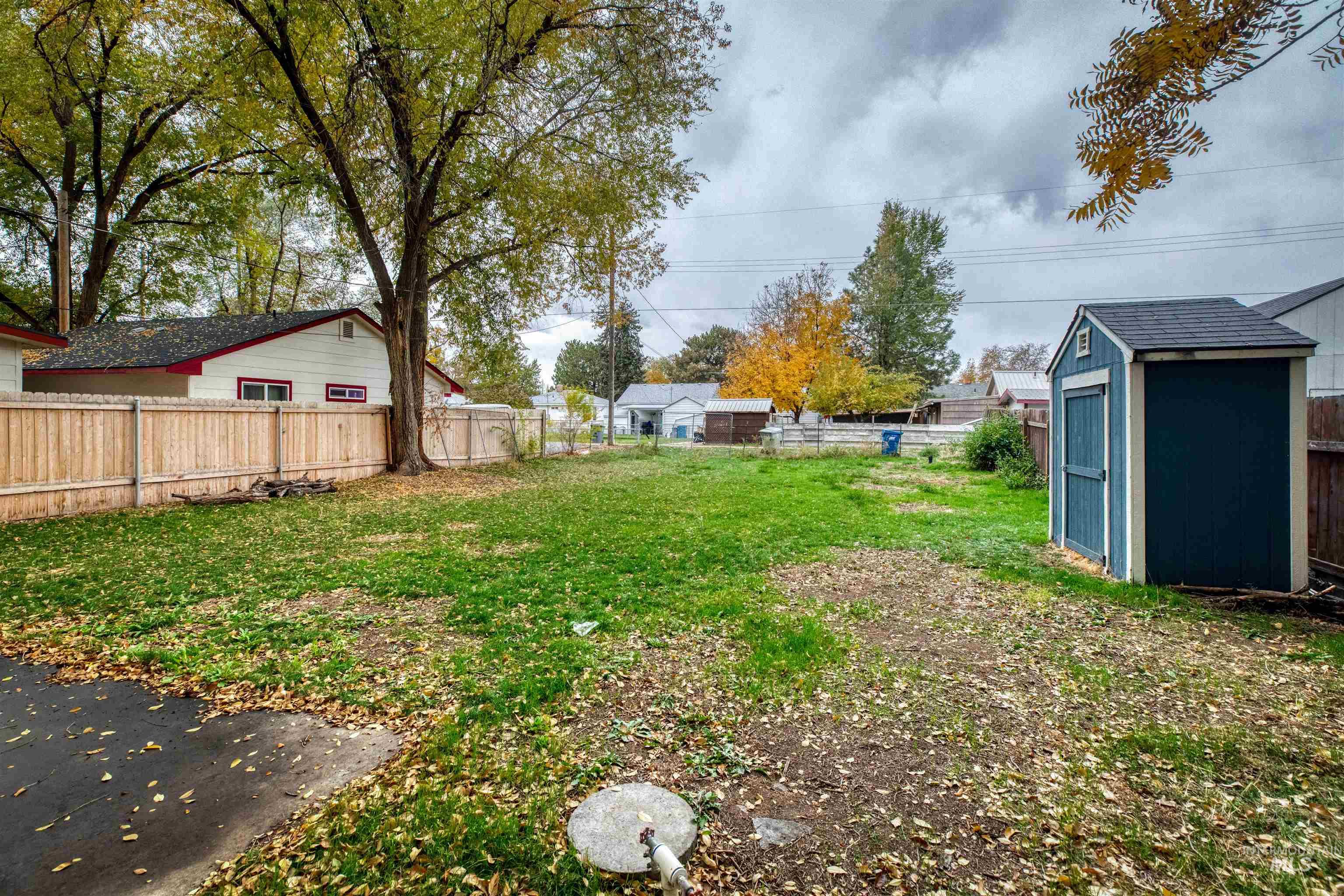 Fenced backyard featuring a storage shed