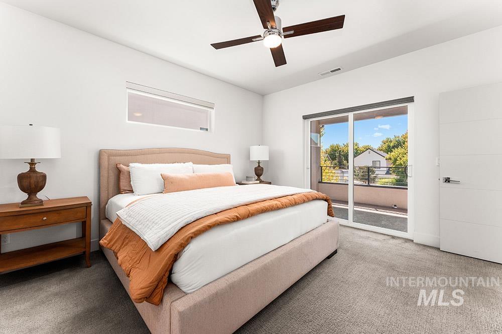 Carpeted bedroom featuring access to outside and ceiling fan