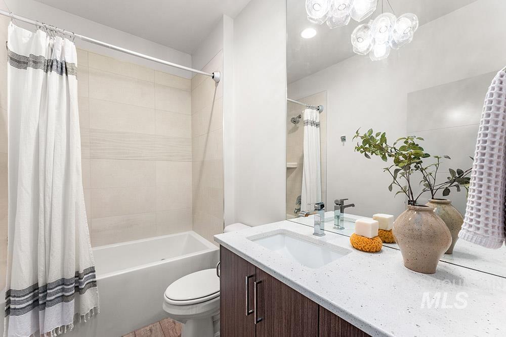 Bathroom with shower / tub combo, vanity, a chandelier, and recessed lighting