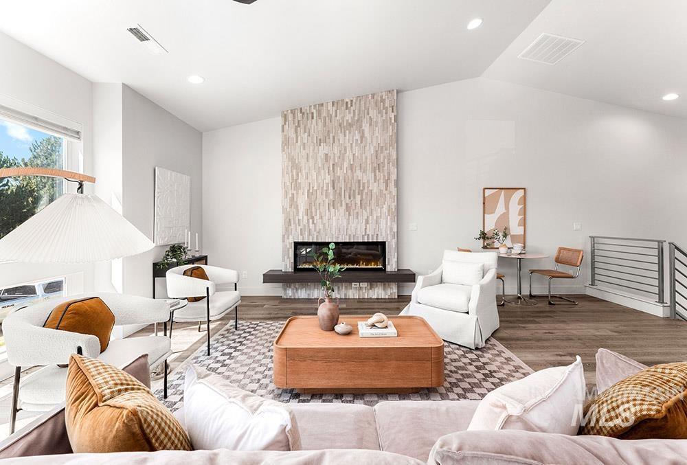 Living area featuring recessed lighting, wood finished floors, a fireplace, and lofted ceiling