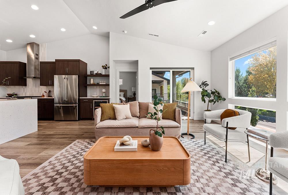 Living room featuring recessed lighting, light wood finished floors, a ceiling fan, beverage cooler, and high vaulted ceiling