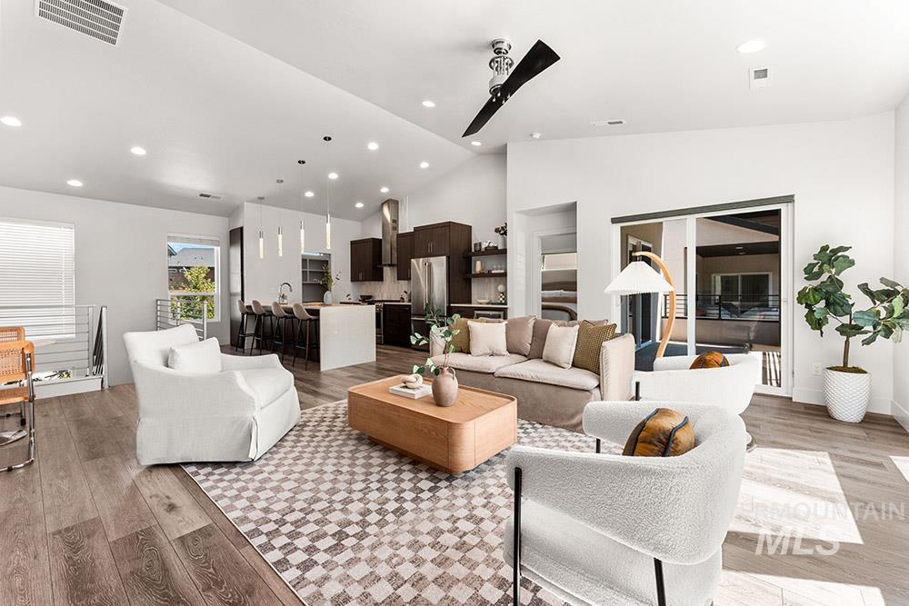 Living area with light wood finished floors, recessed lighting, and high vaulted ceiling