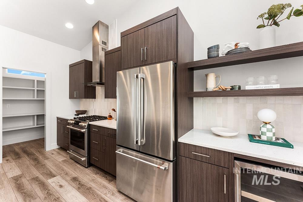 Kitchen featuring open shelves, stainless steel appliances, wine cooler, dark brown cabinets, and backsplash