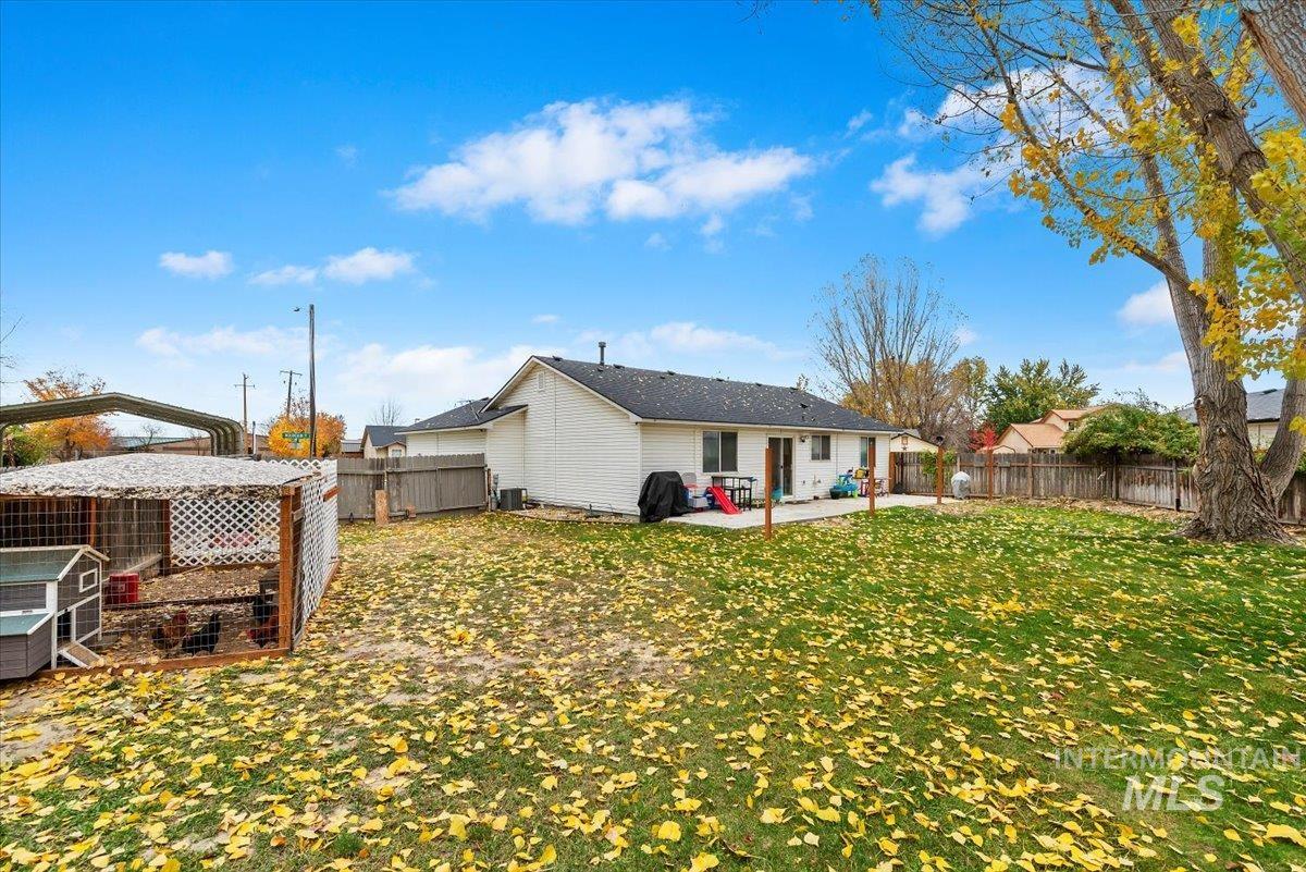 Back of house featuring a fenced backyard, a patio area, an outbuilding, and exterior structure