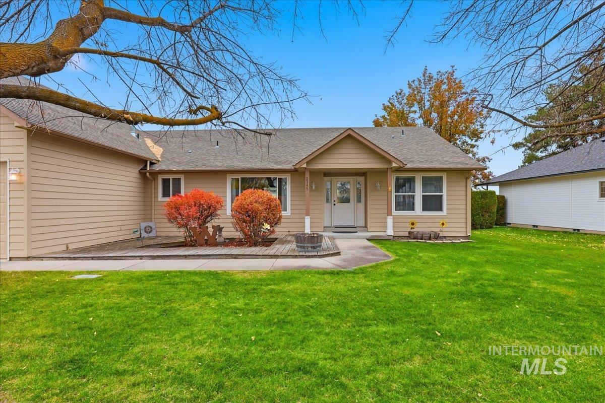 View of front of property featuring a front yard and roof with shingles