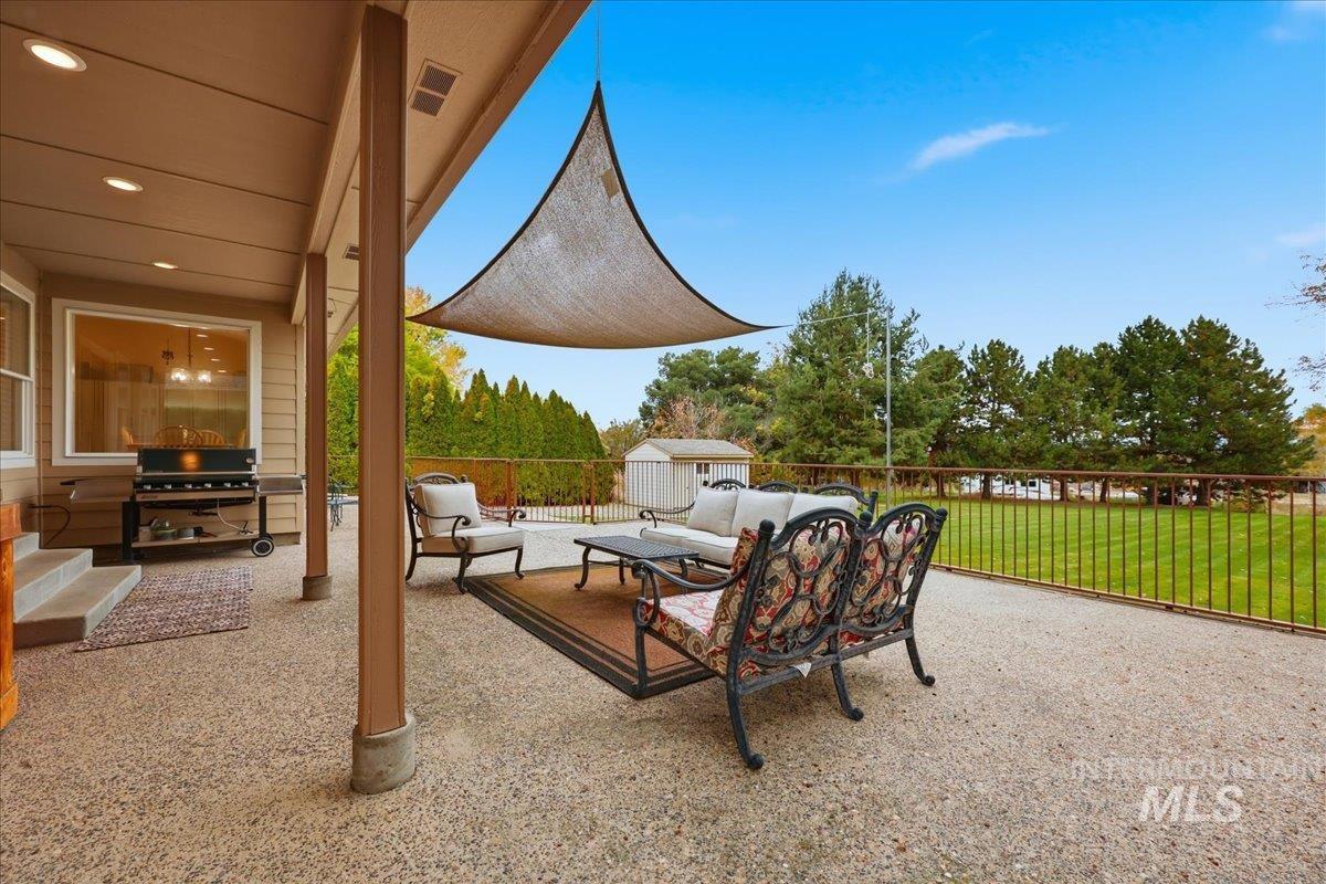 View of patio with a storage unit, a grill, and an outdoor hangout area