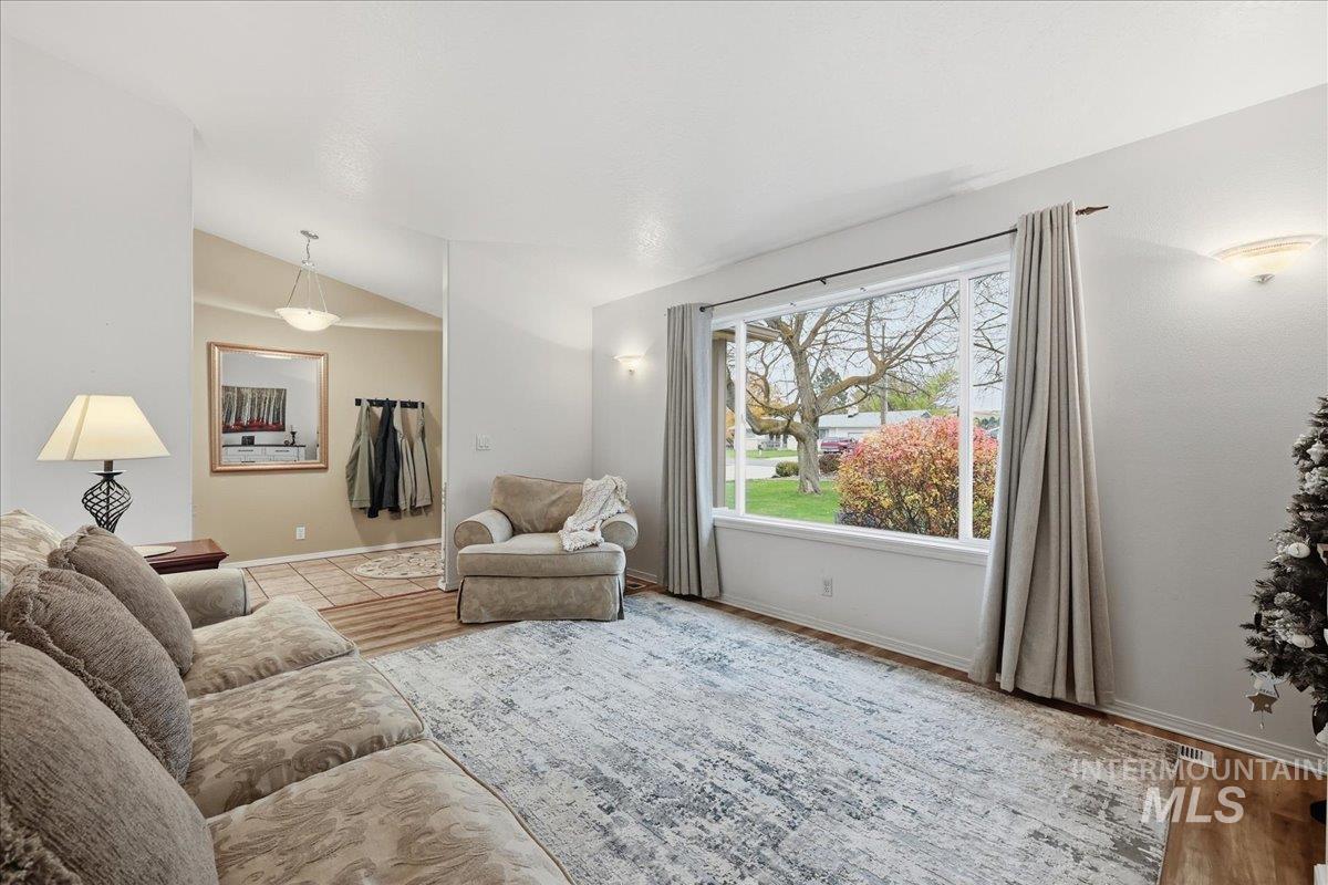 Living room featuring light wood finished floors and vaulted ceiling