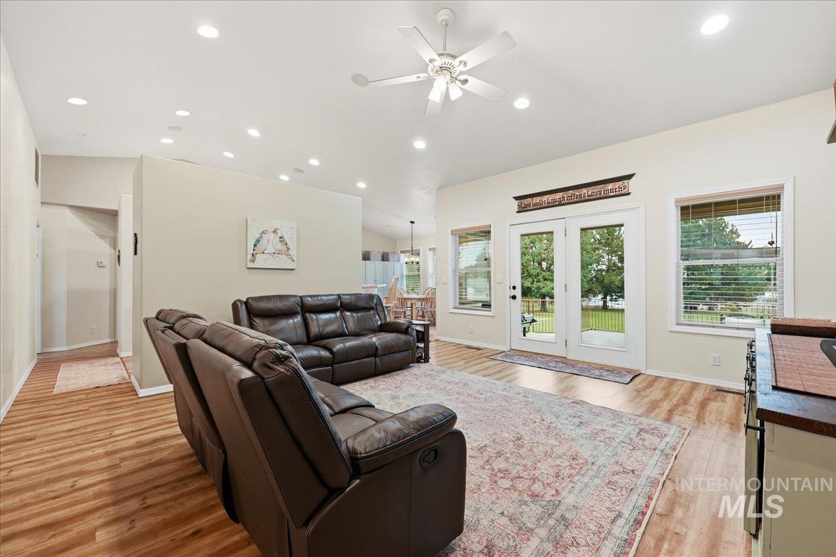 Living area featuring recessed lighting, light wood finished floors, a ceiling fan, and lofted ceiling