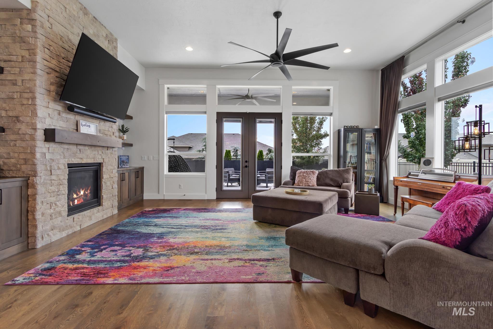 Living area with plenty of natural light, wood finished floors, a fireplace, and recessed lighting