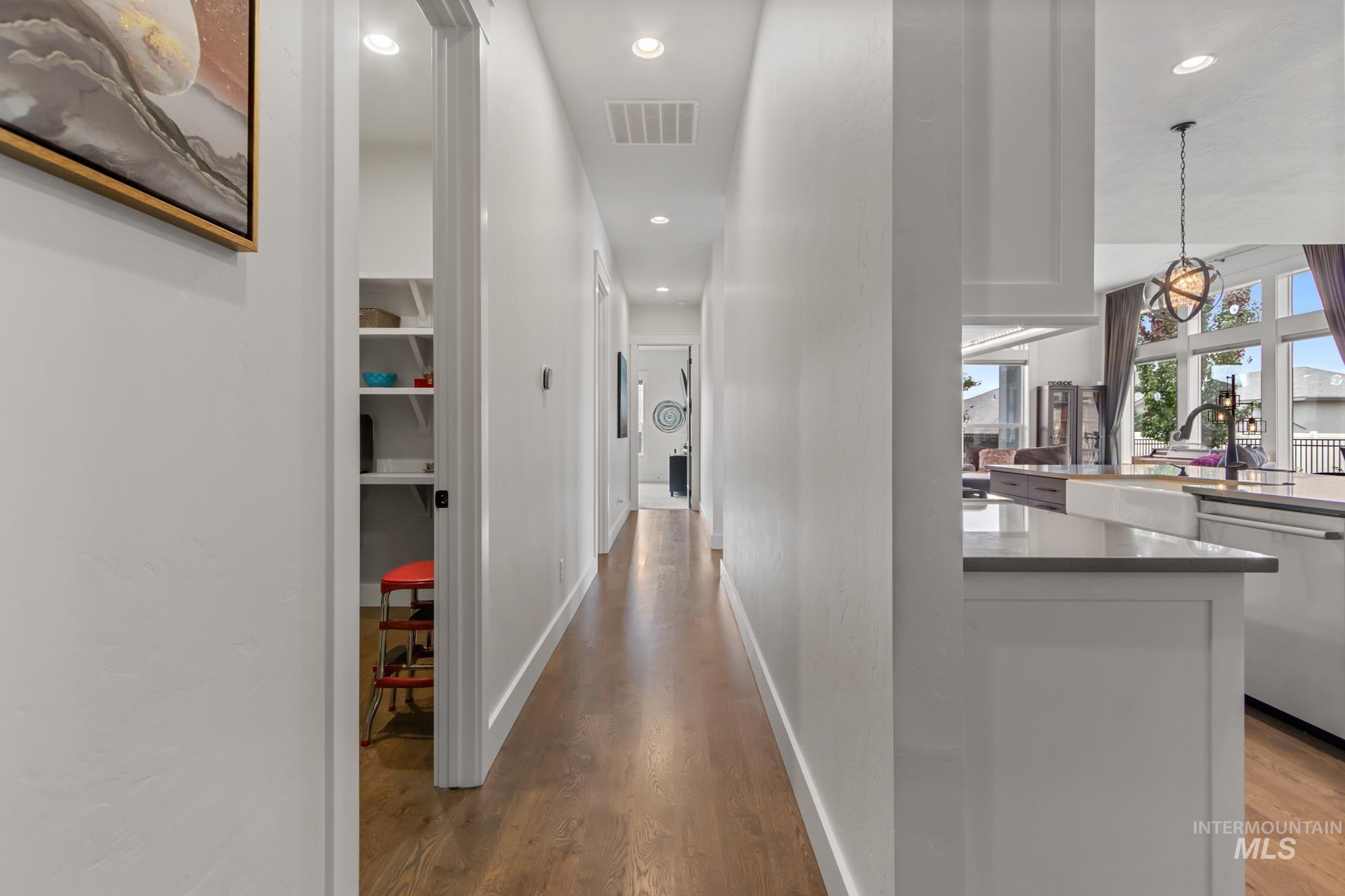 Hallway with dark wood-type flooring and recessed lighting