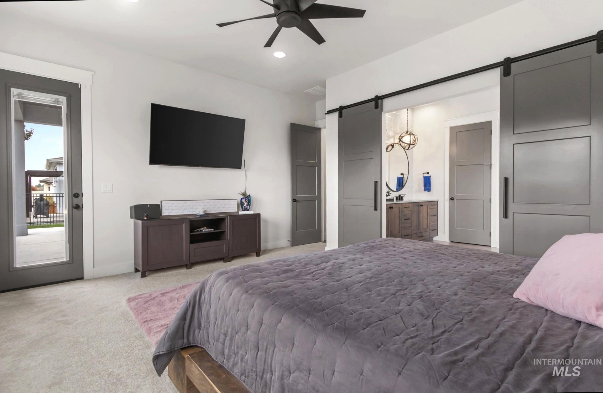 Carpeted bedroom featuring a barn door, recessed lighting, access to exterior, and ceiling fan
