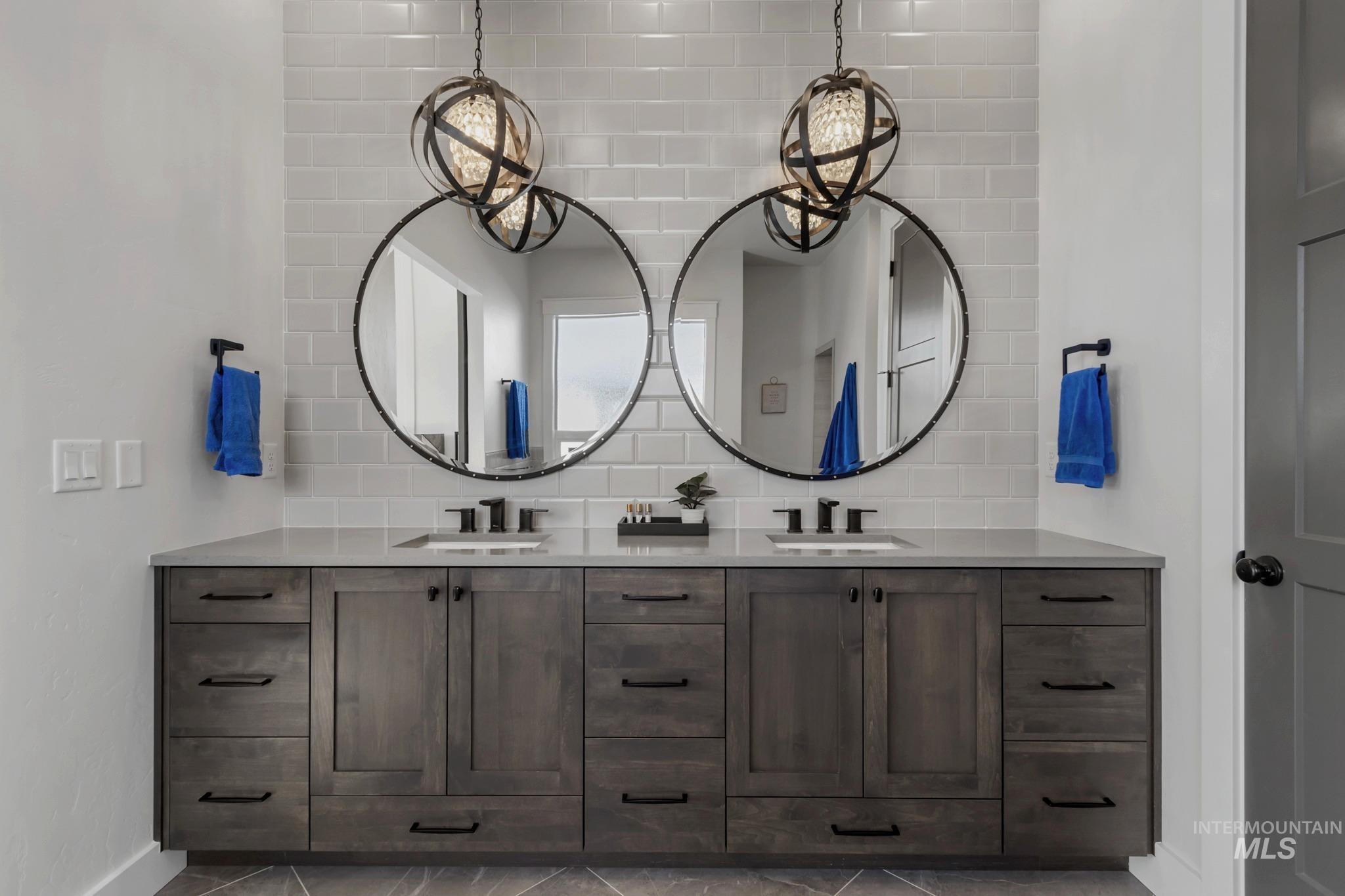 Bathroom featuring double vanity and decorative backsplash