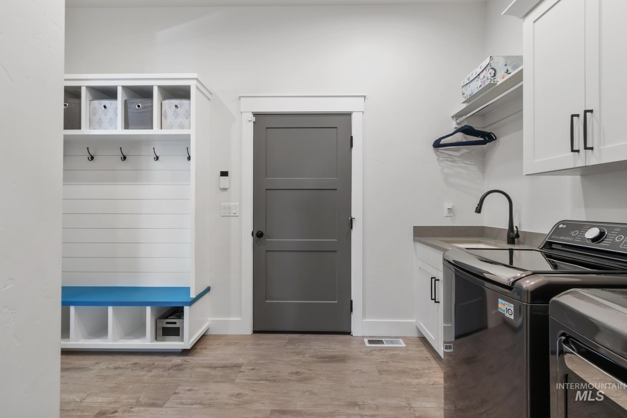 Laundry area featuring cabinet space, light wood-type flooring, and separate washer and dryer