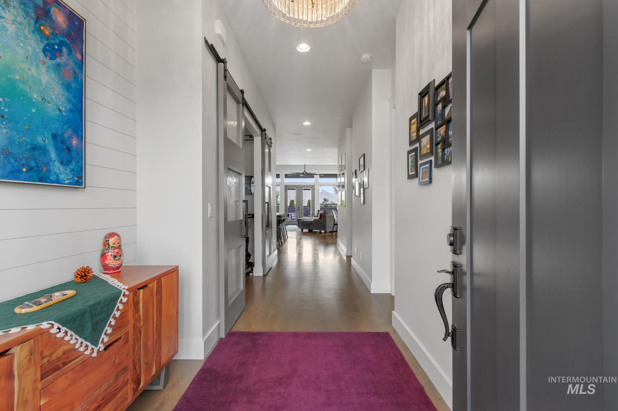 Hall with a barn door, recessed lighting, and dark wood-type flooring