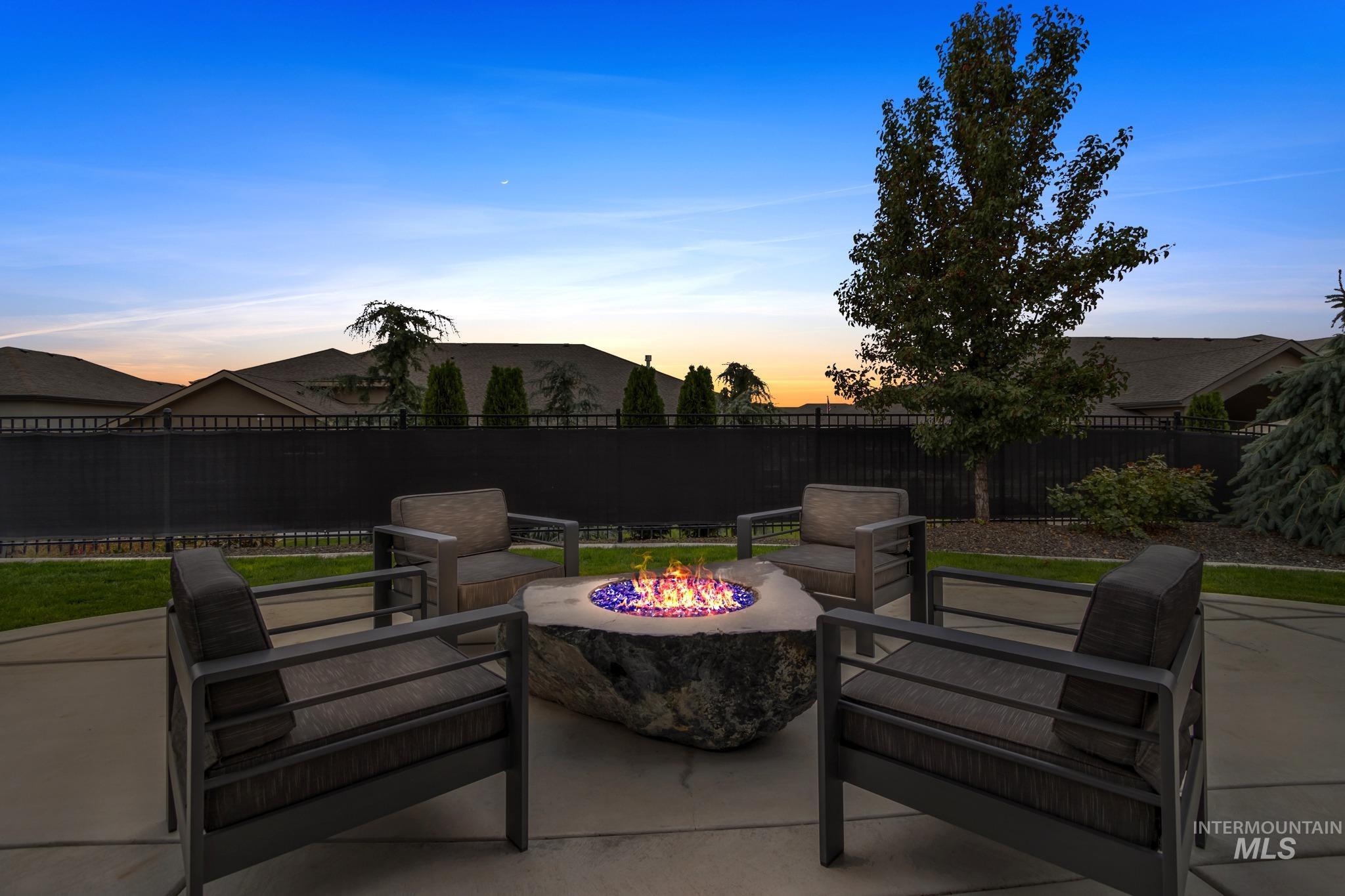 Patio terrace at dusk featuring a patio, a fenced backyard, and an outdoor fire pit