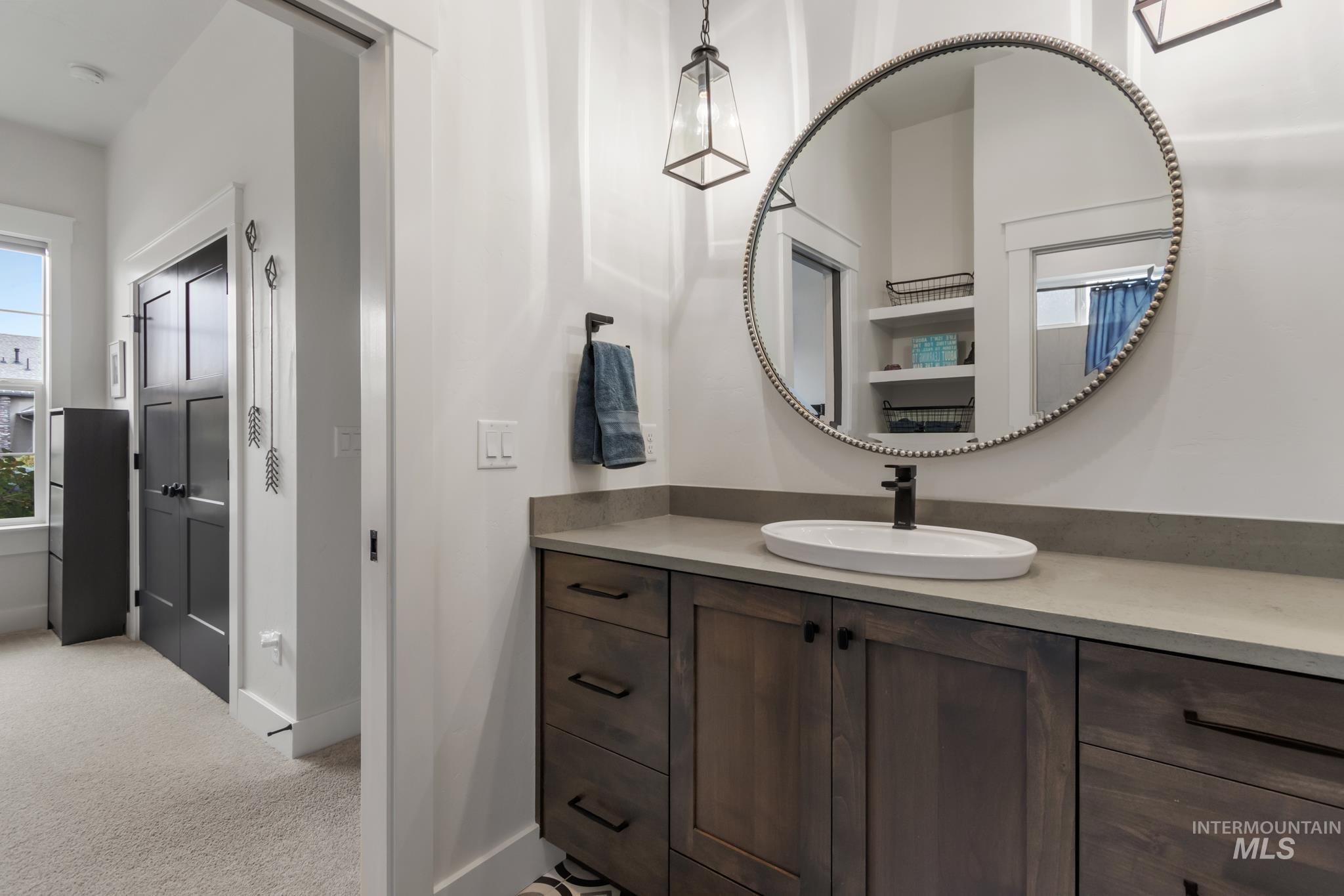 Bathroom featuring healthy amount of natural light, vanity, and light colored carpet