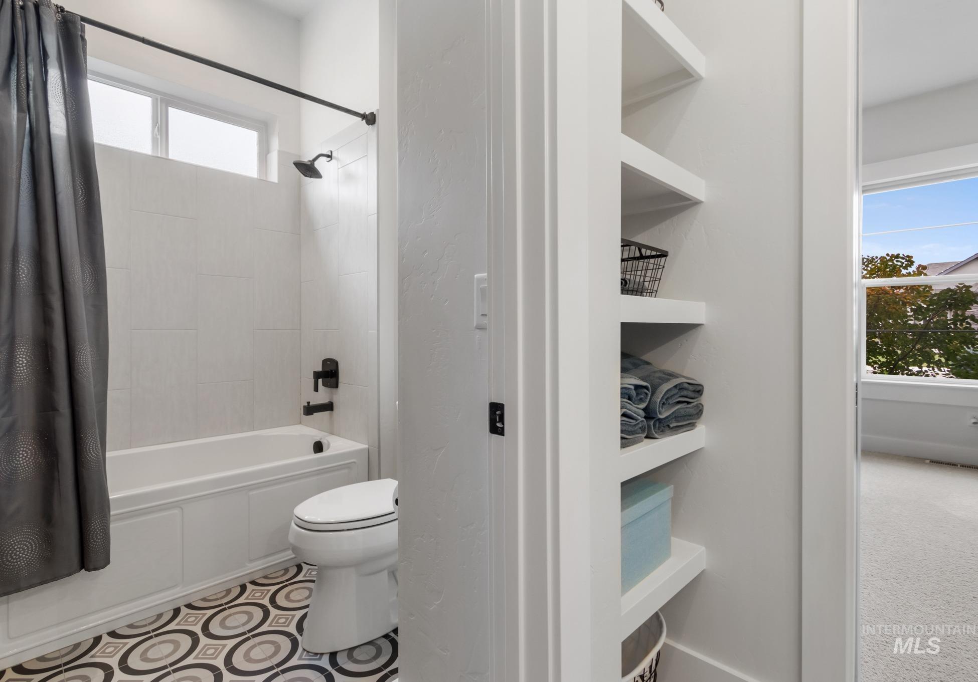 Full bath featuring shower / tub combo with curtain and toilet