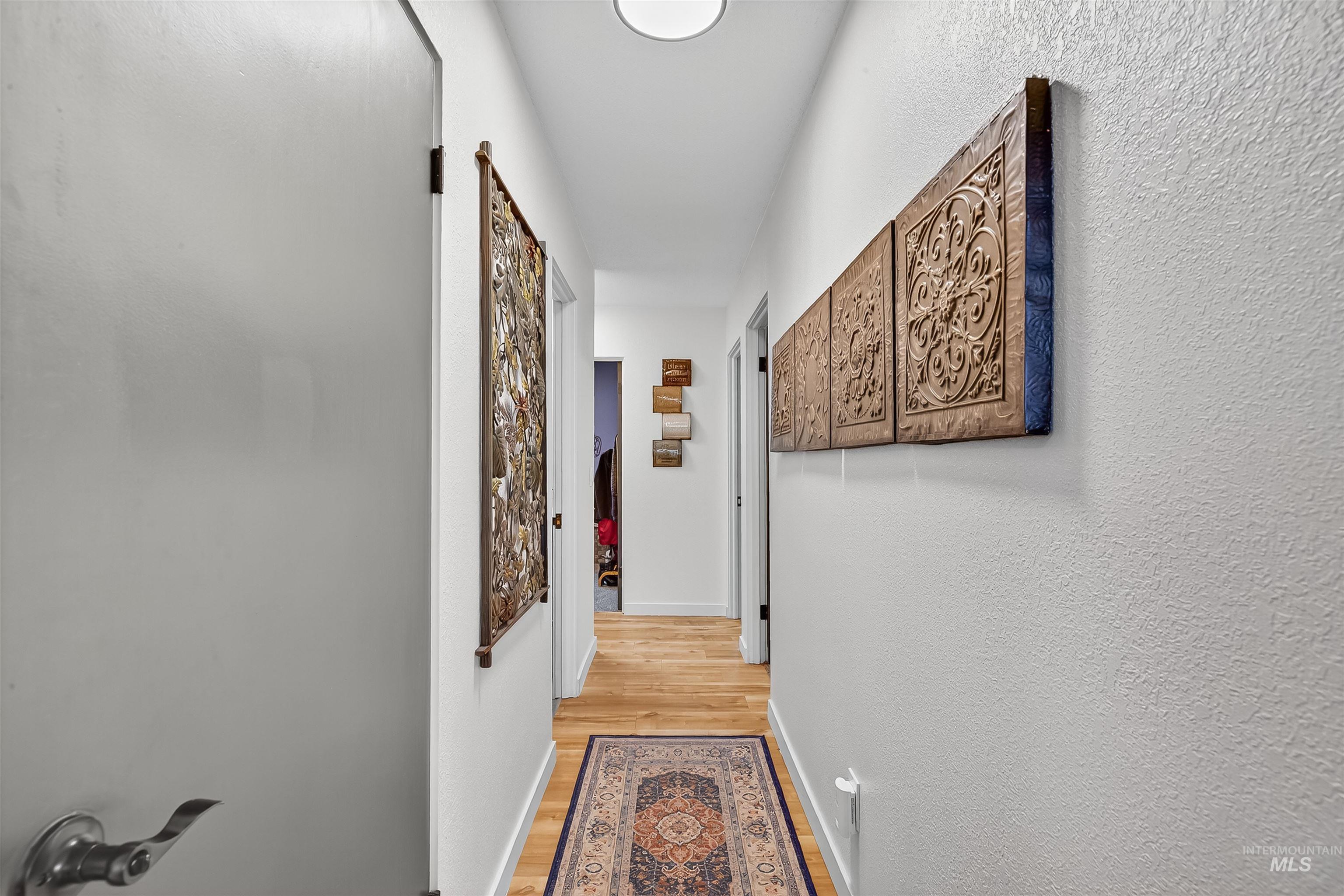 Hallway with light wood-style flooring and baseboards