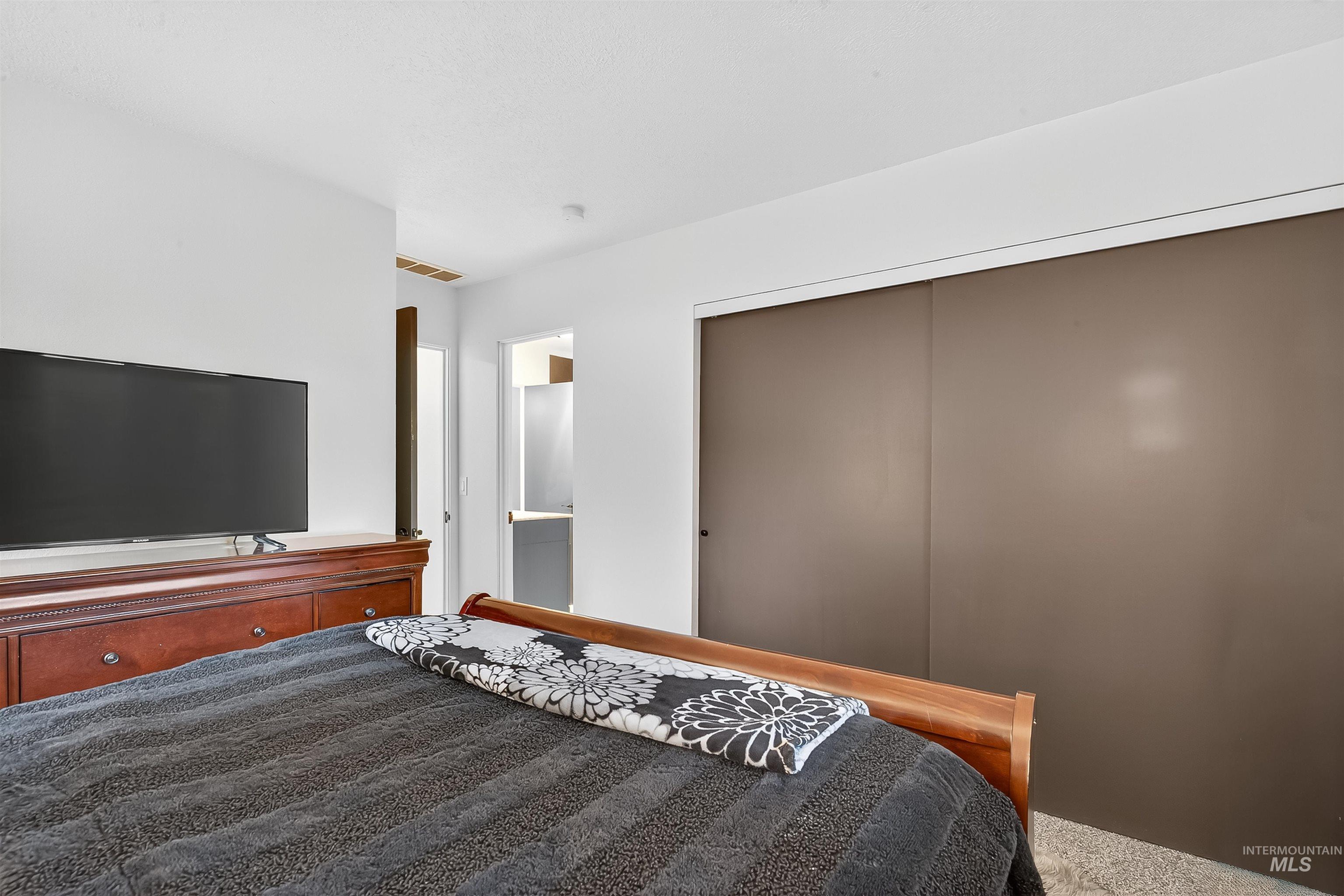 Bedroom featuring a closet, ensuite bath, and carpet