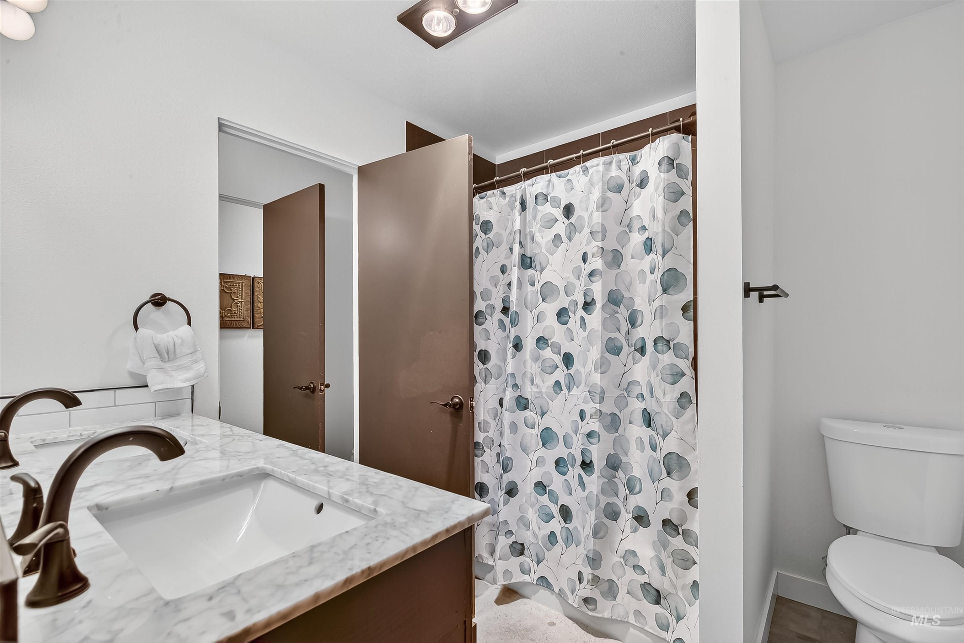 Full bathroom with a shower with shower curtain and vanity