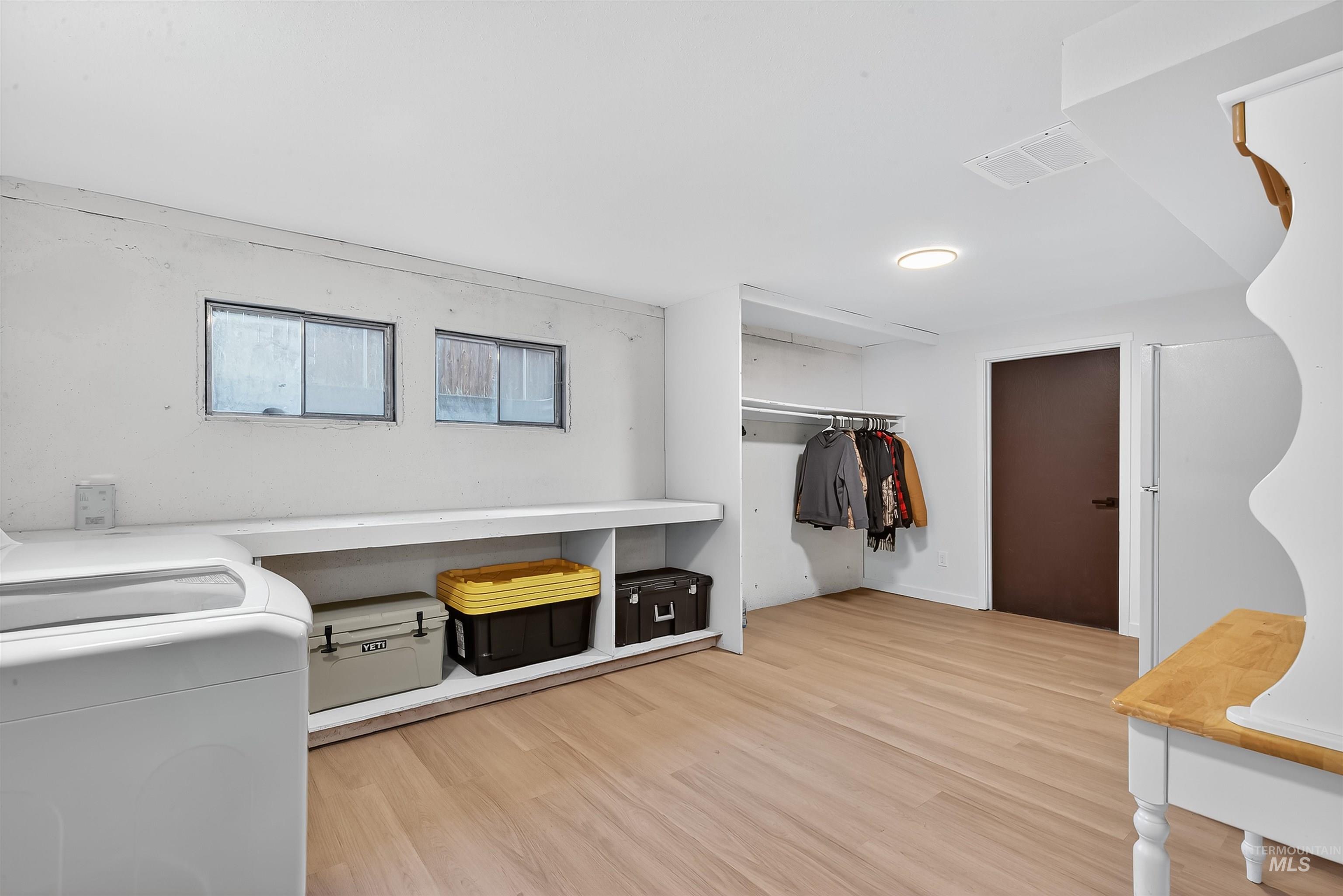 Spacious closet with light wood-style flooring and washer / clothes dryer