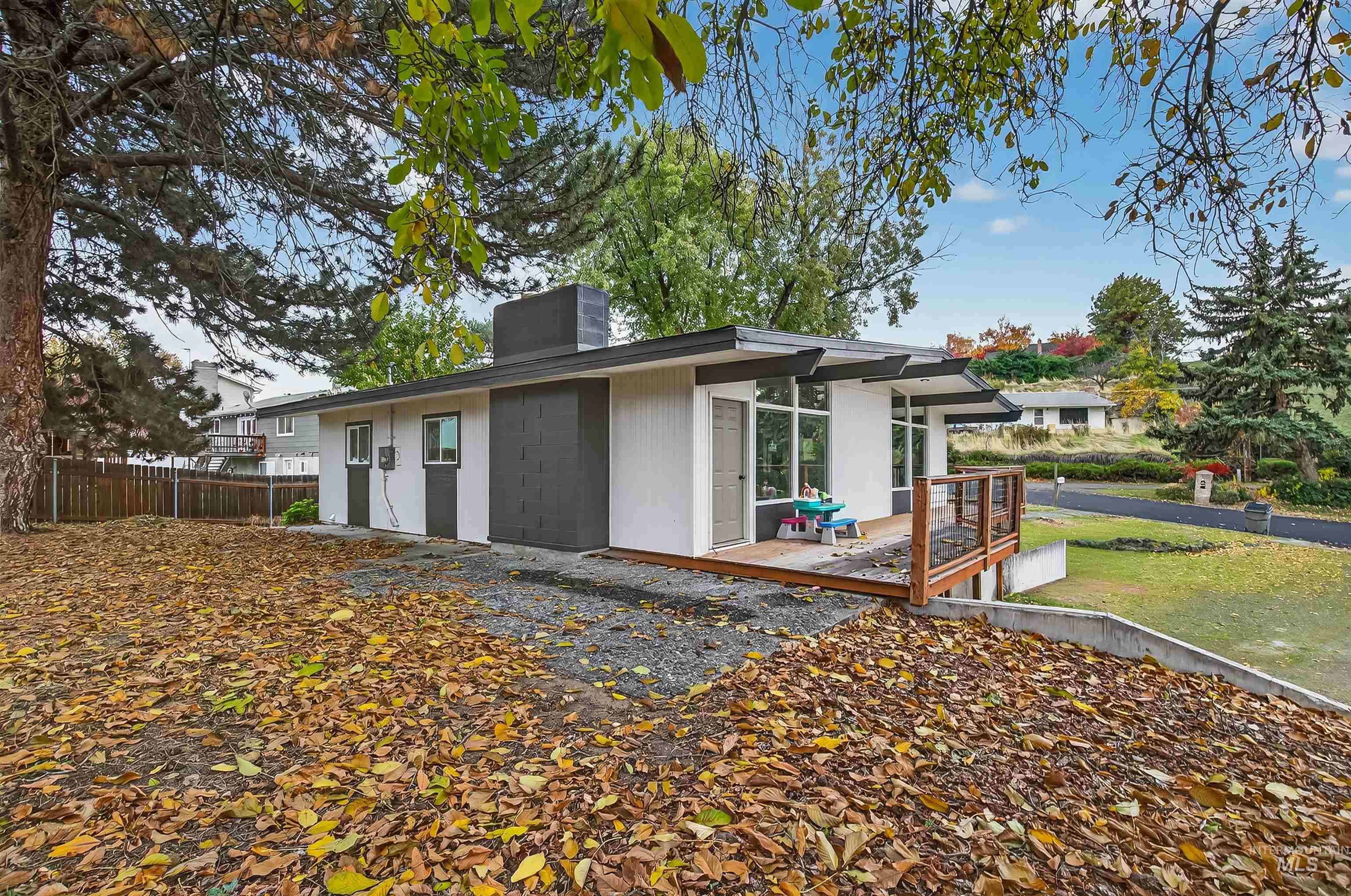 View of side of property with a deck, a chimney, and stucco siding