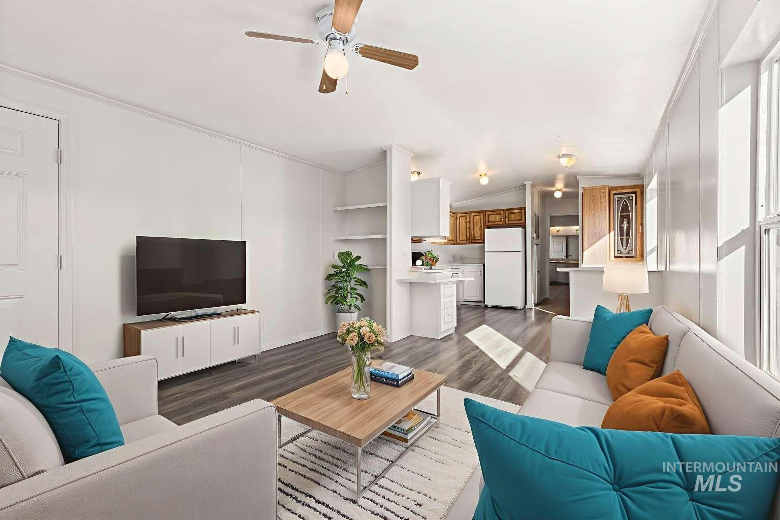 Living area with wood finished floors, ceiling fan, lofted ceiling, and crown molding