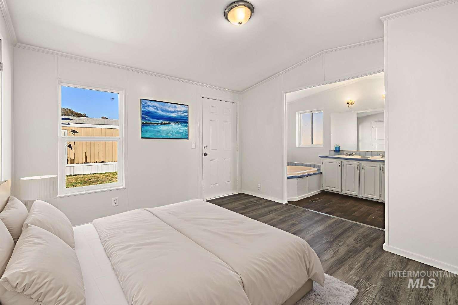 Bedroom featuring dark wood finished floors and lofted ceiling