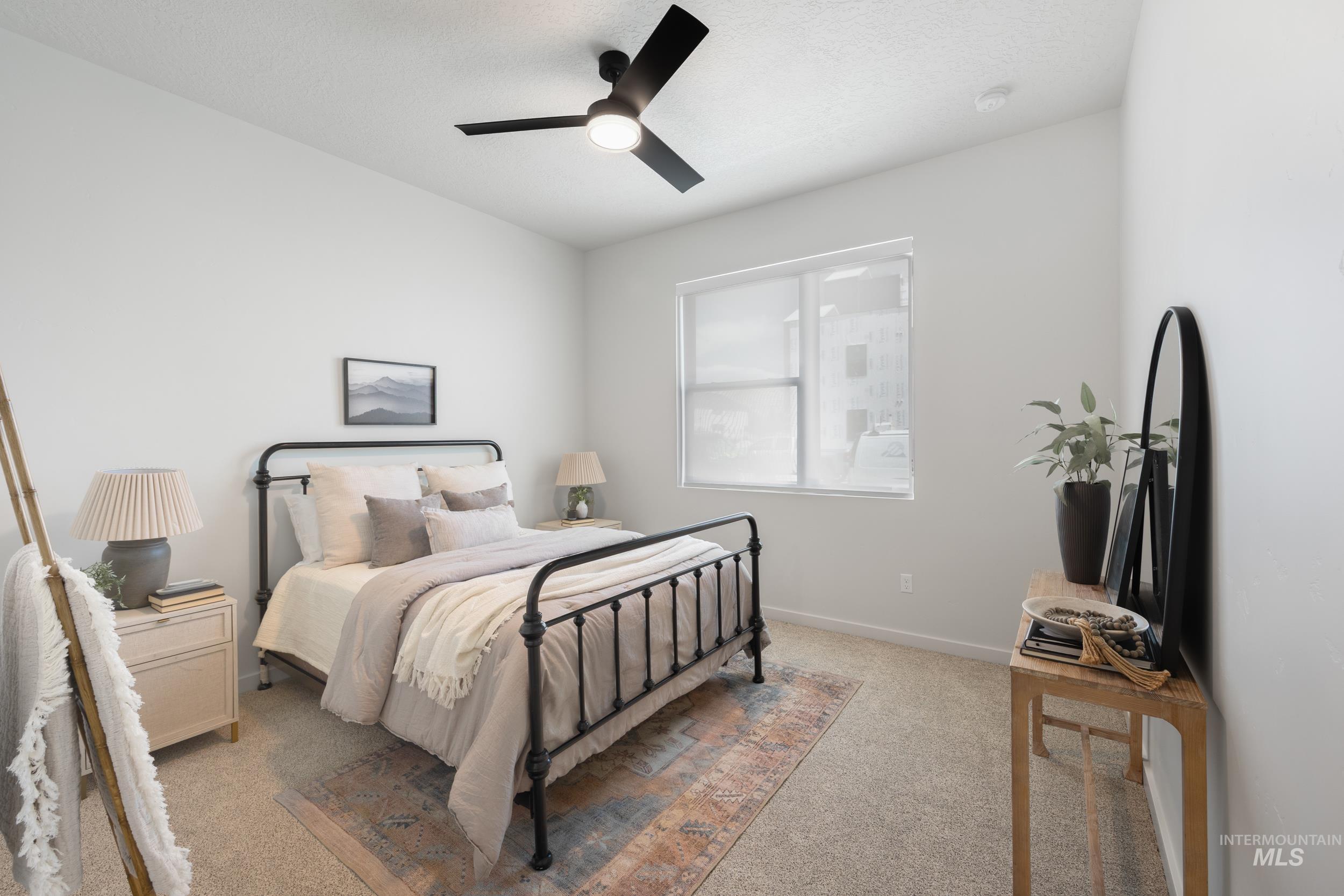 Bedroom with light colored carpet, a ceiling fan, and a textured ceiling